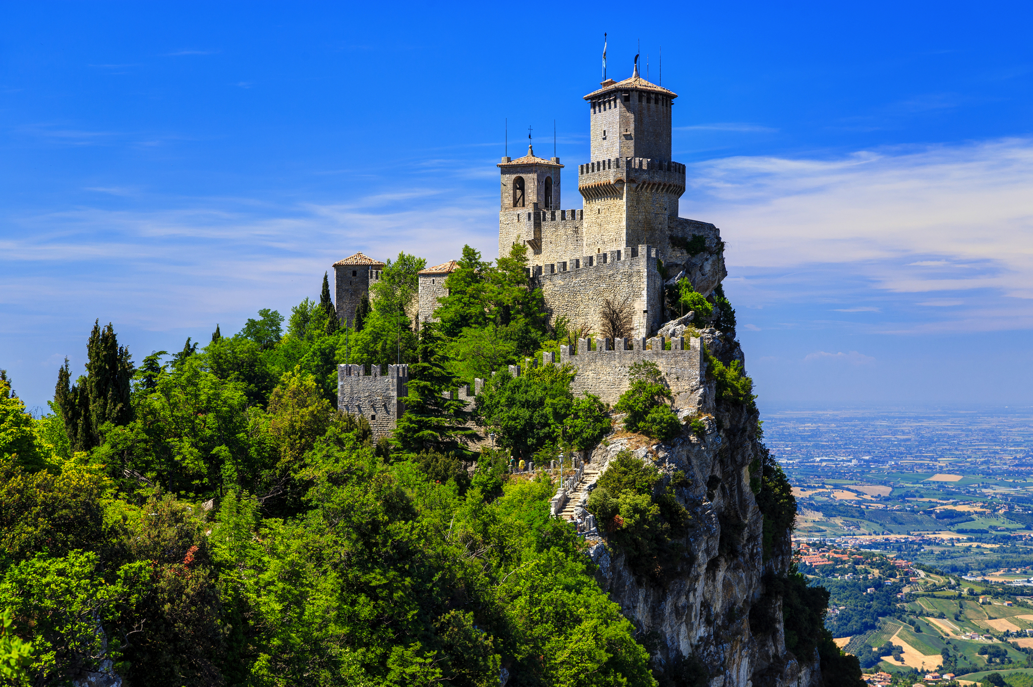 Burg auf einem Hügel mit Ausblick auf die Landschaft bei sonnigem Wetter.