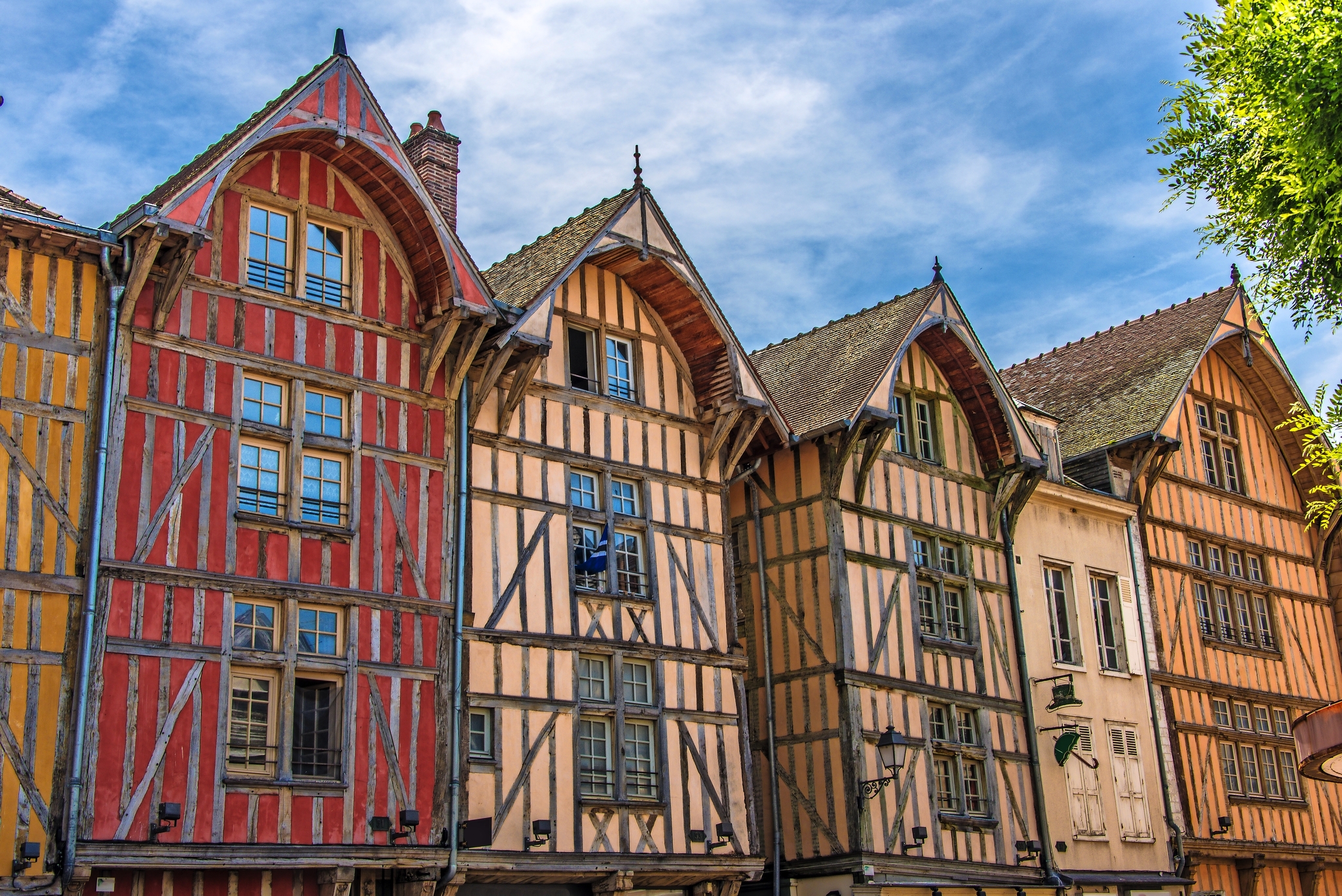 Fachwerkhäuser mit farbigen Fassaden in einer historischen europäischen Stadt bei klarem Himmel.