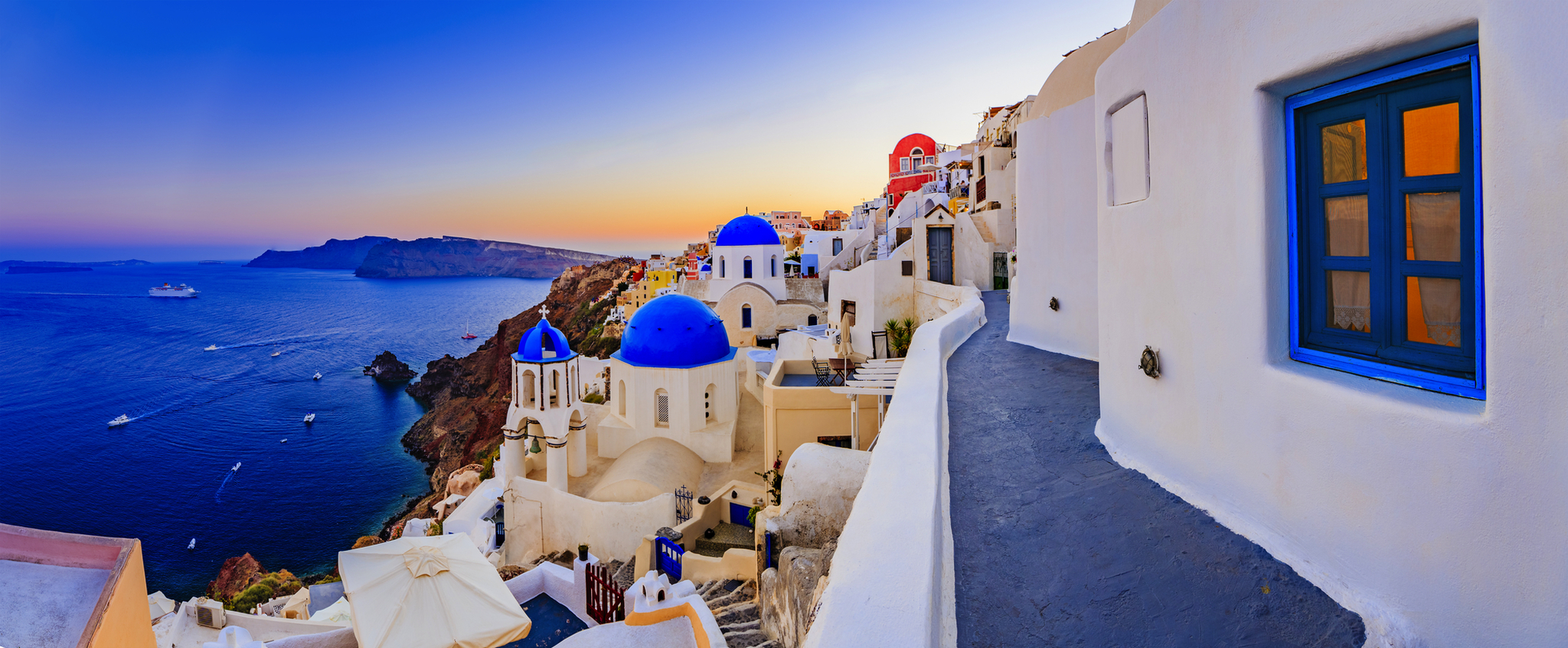 Weiß-blaue Häuser und Meerblick bei Sonnenuntergang auf Santorini, Griechenland.