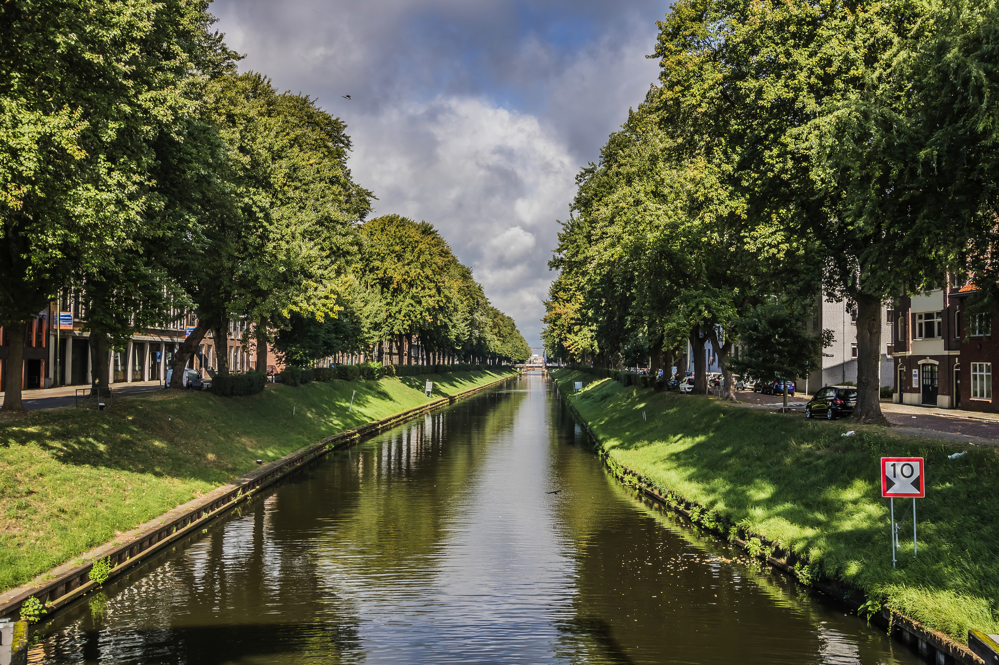 Kanal mit Bäumen an den Ufern und einem Geschwindigkeitsbegrenzungsschild im Vordergrund.