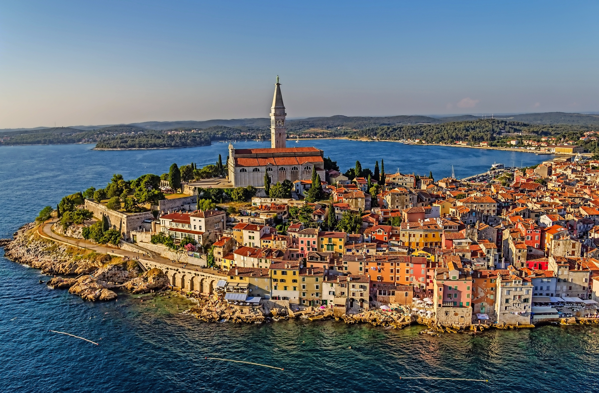 Küstenstadt mit alter Kirche und bunten Häusern am Meer.