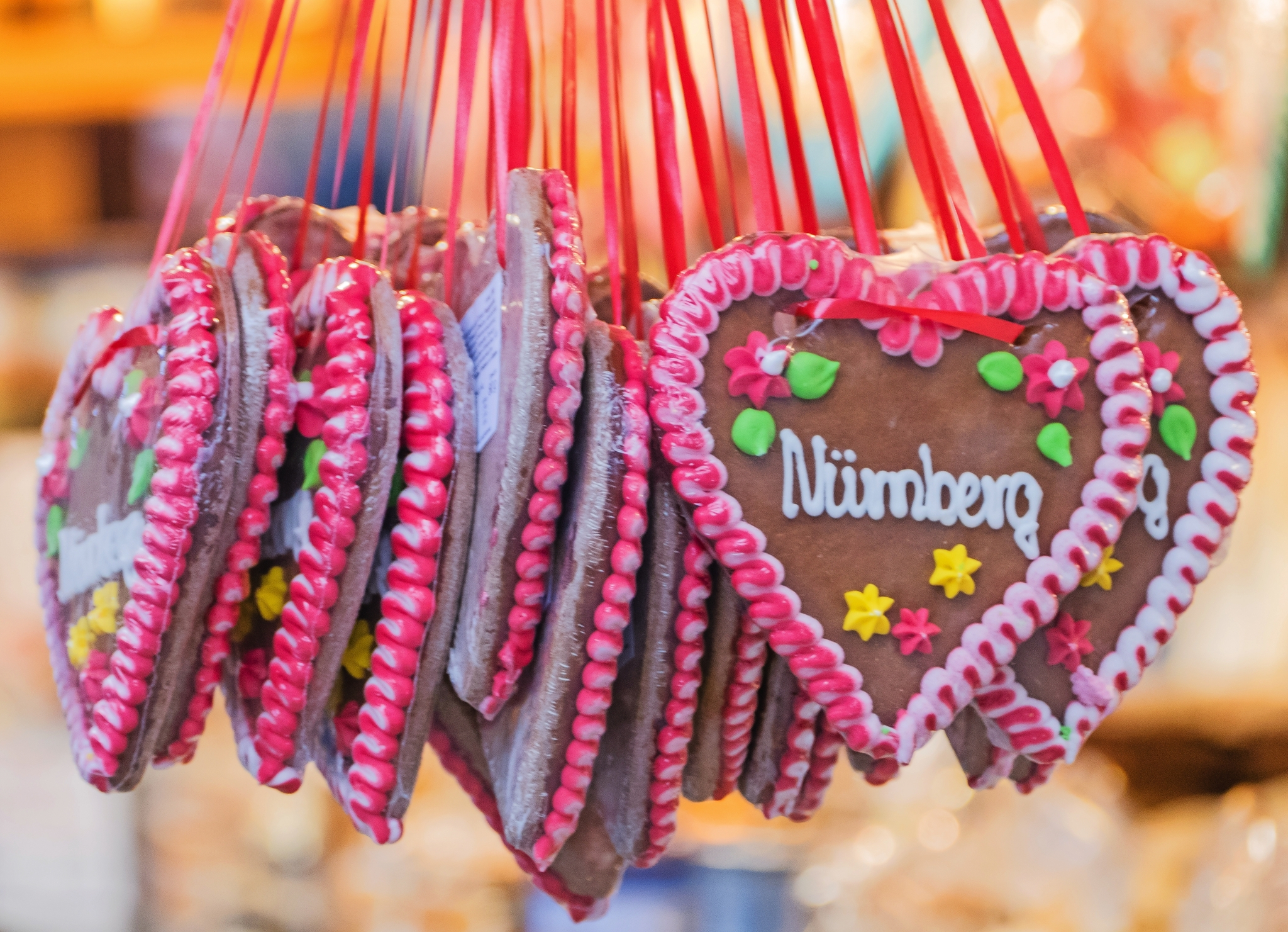 Lebkuchenherzen mit Zuckerguss und der Aufschrift "Nürnberg" an roten Bändern.