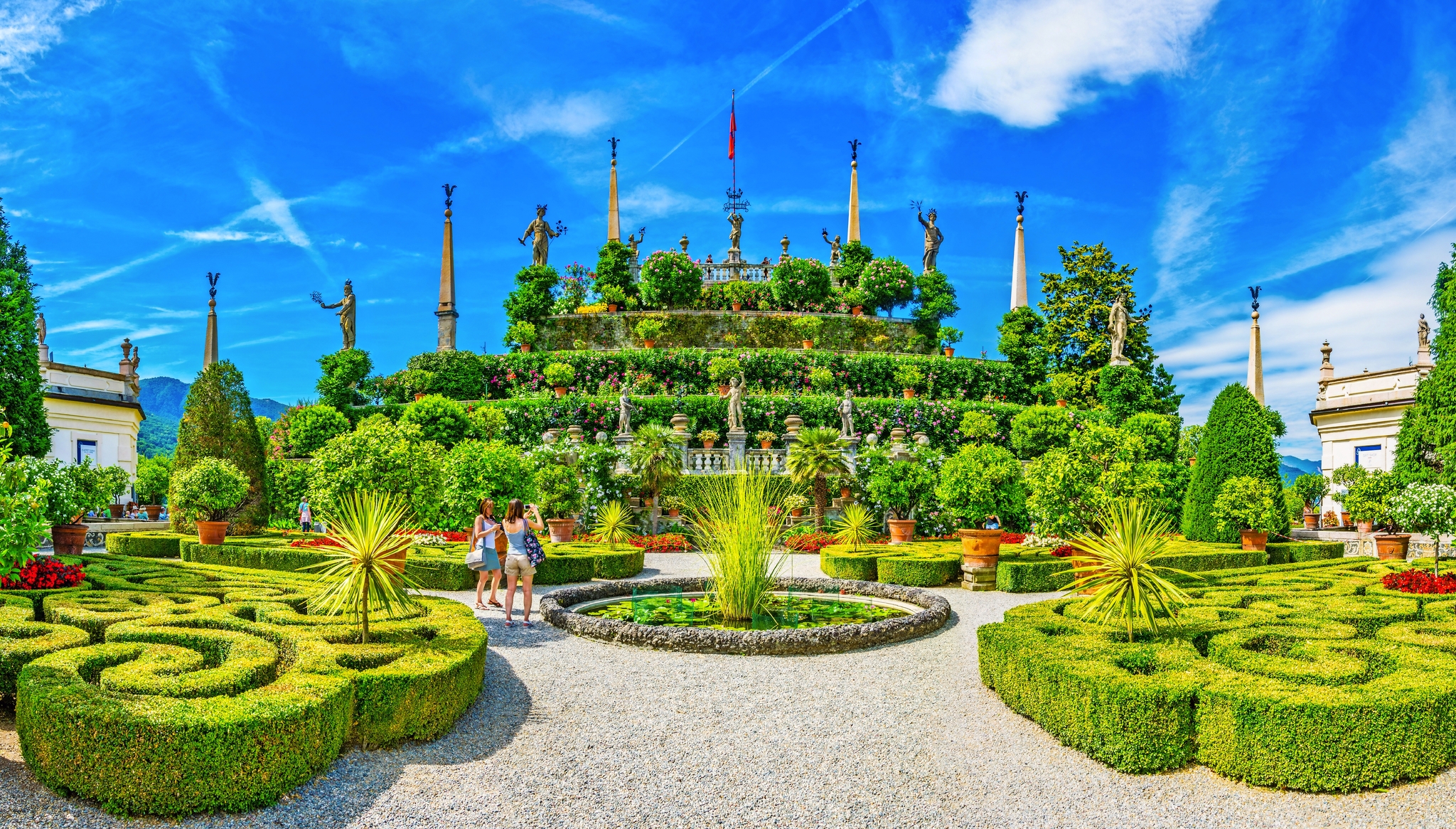 Terrassenförmiger italienischer Garten mit Statuen und kunstvoll geschnittenen Hecken.