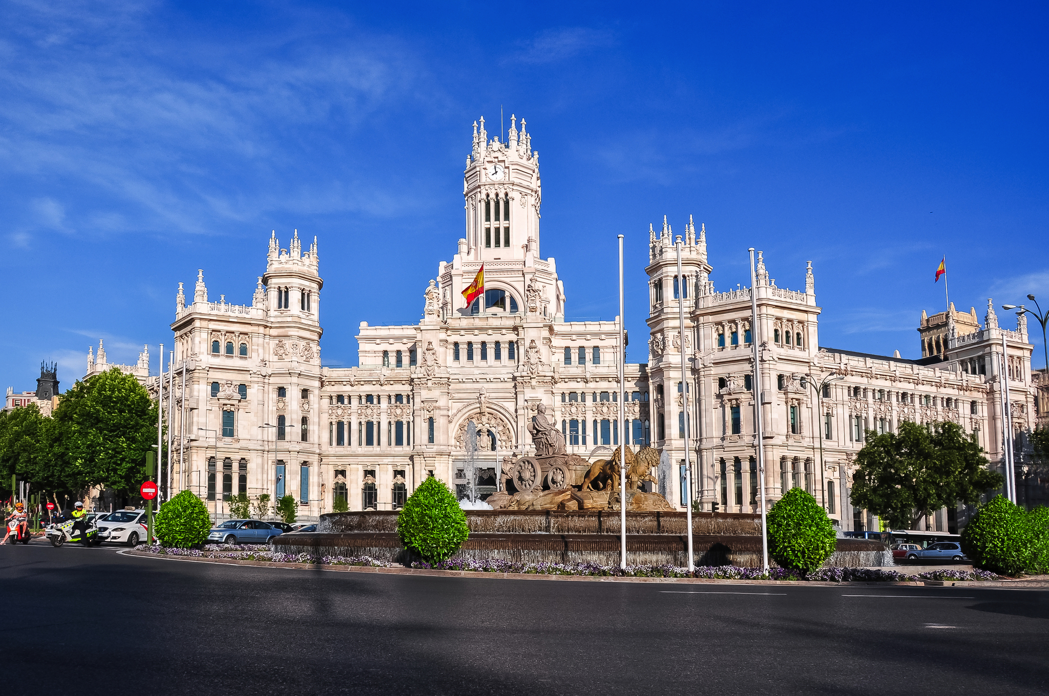 Historisches Gebäude in Madrid mit Brunnen und klarer blauer Himmel.
