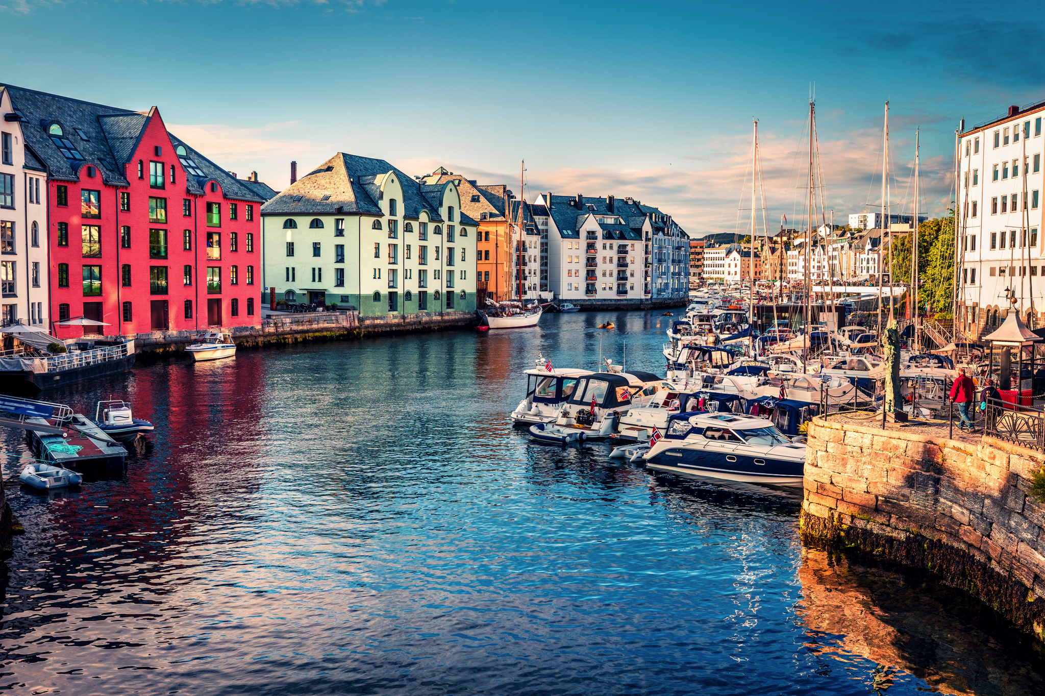 Bunte Gebäude und Boote an einer Küste, klarer Himmel.
