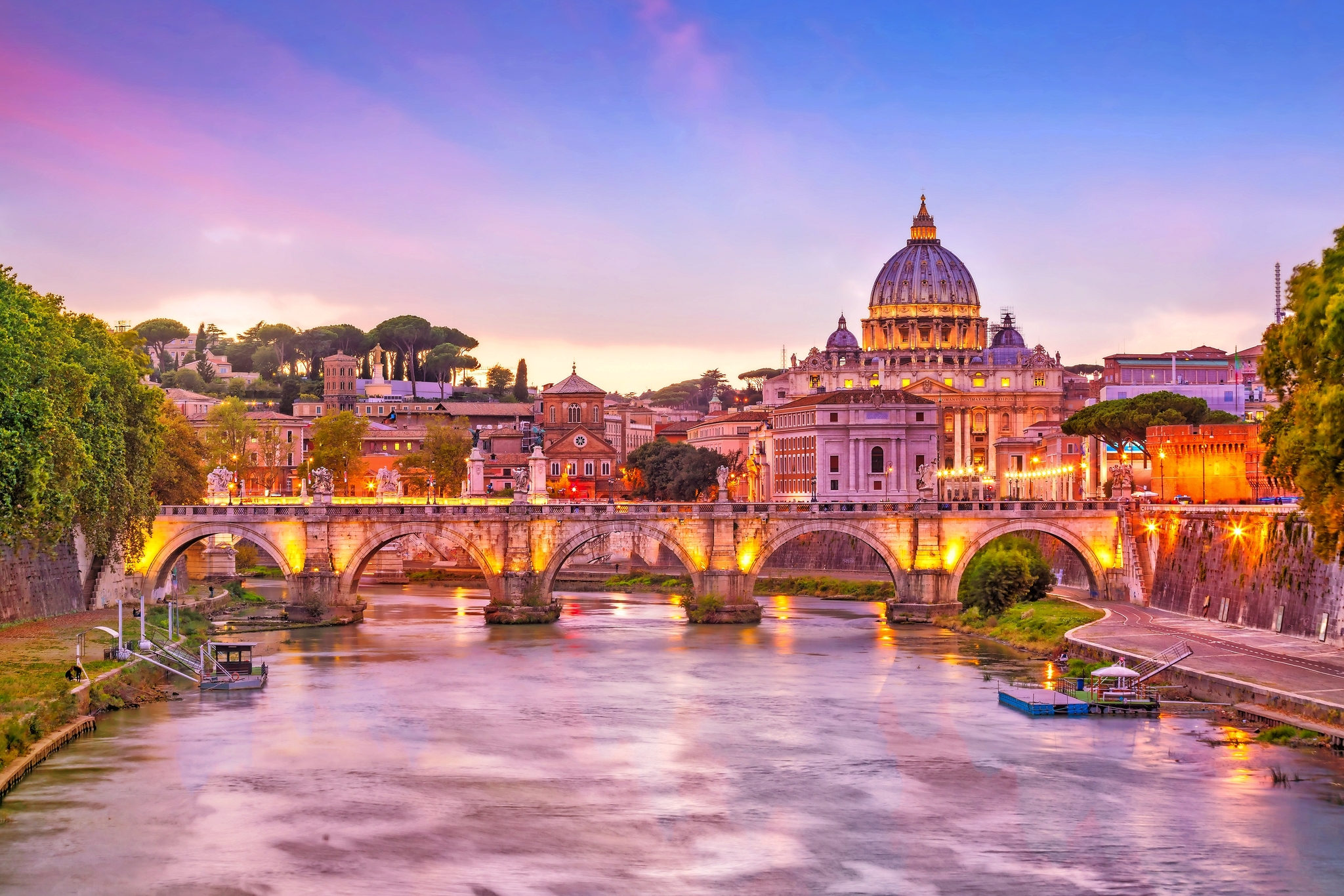 Blick auf den Petersdom und die Engelsbrücke in Rom bei Sonnenuntergang.
