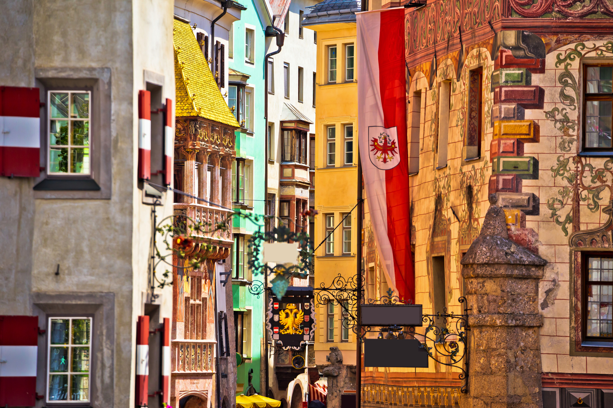 Bunte historische Gebäude in einer europäischen Altstadt mit Wappenfahne.