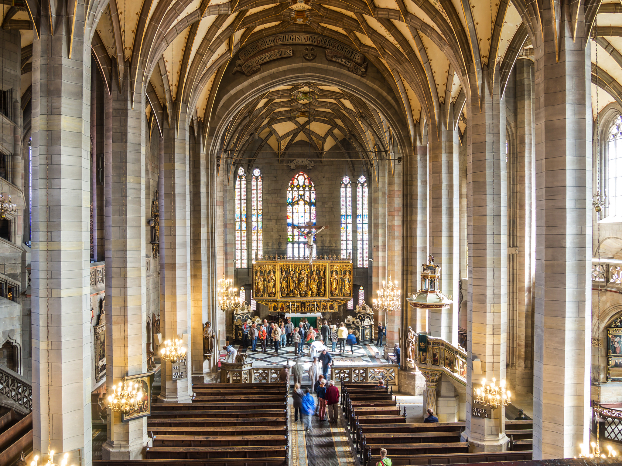 Gotische Kircheninnenansicht mit Buntglasfenstern und Besuchern