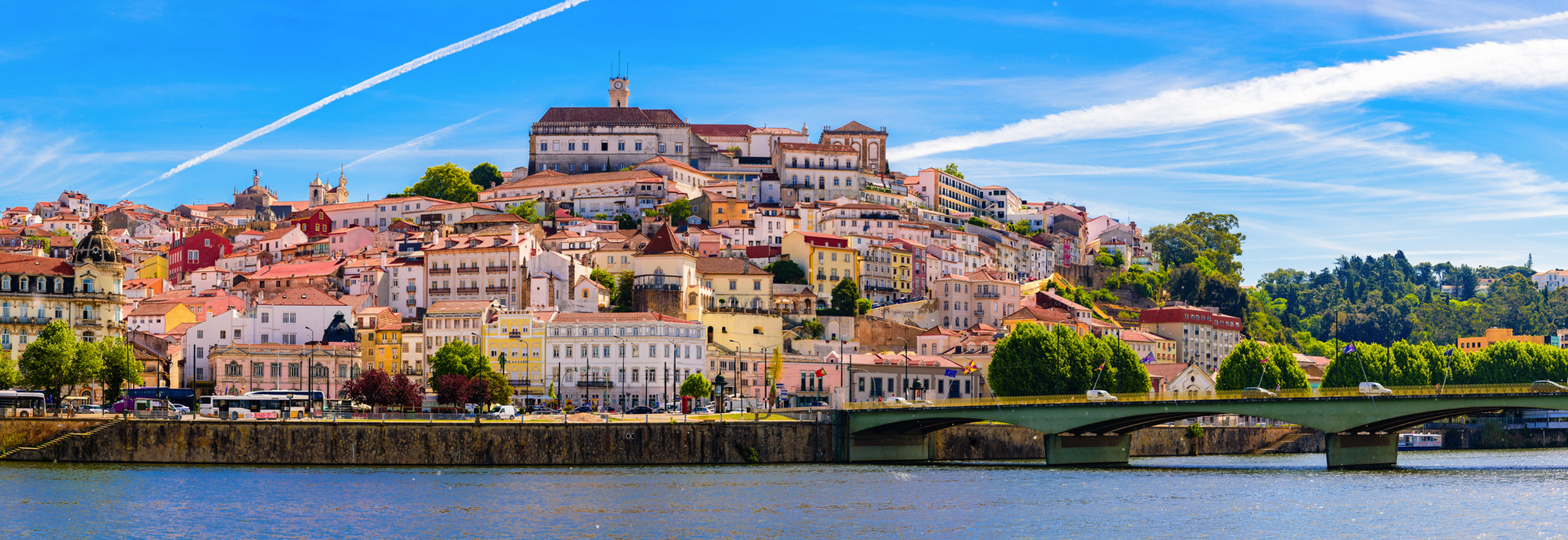 Stadtansicht mit Fluss und Brücke im Vordergrund.