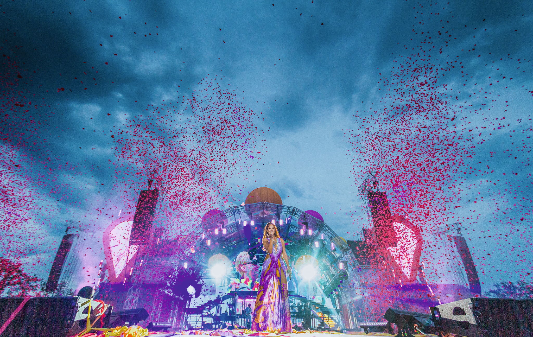 Bühne bei einem Open-Air-Konzert mit Lichtshow und Konfetti im Abendhimmel.