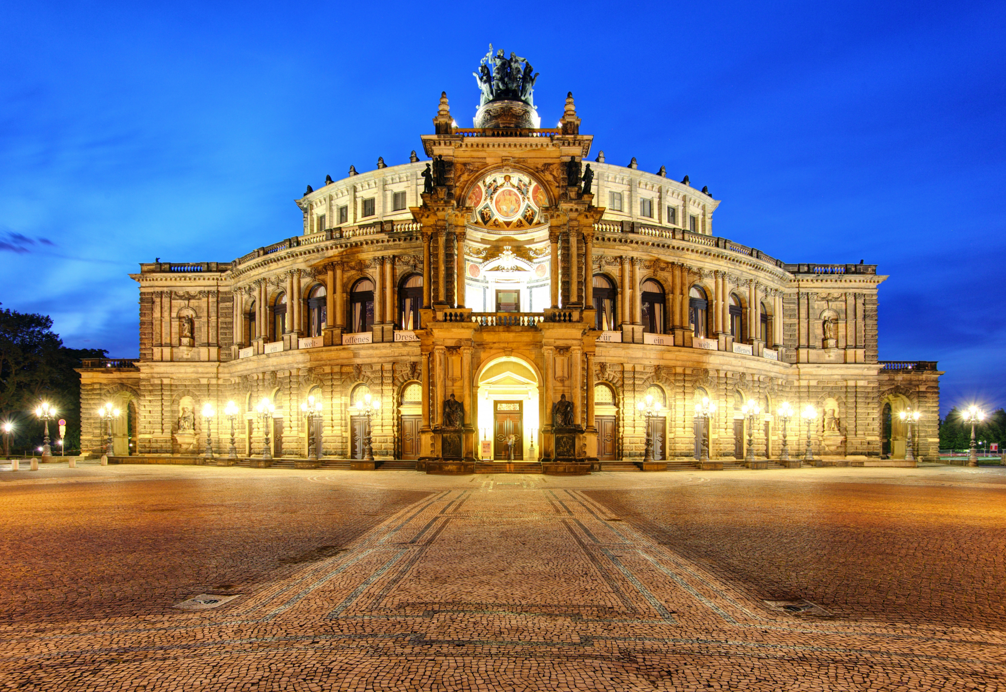 Semperoper in Dresden, Deutschland Historisches Opernhaus bei Abenddämmerung, beleuchtet vor blauem Himmel.