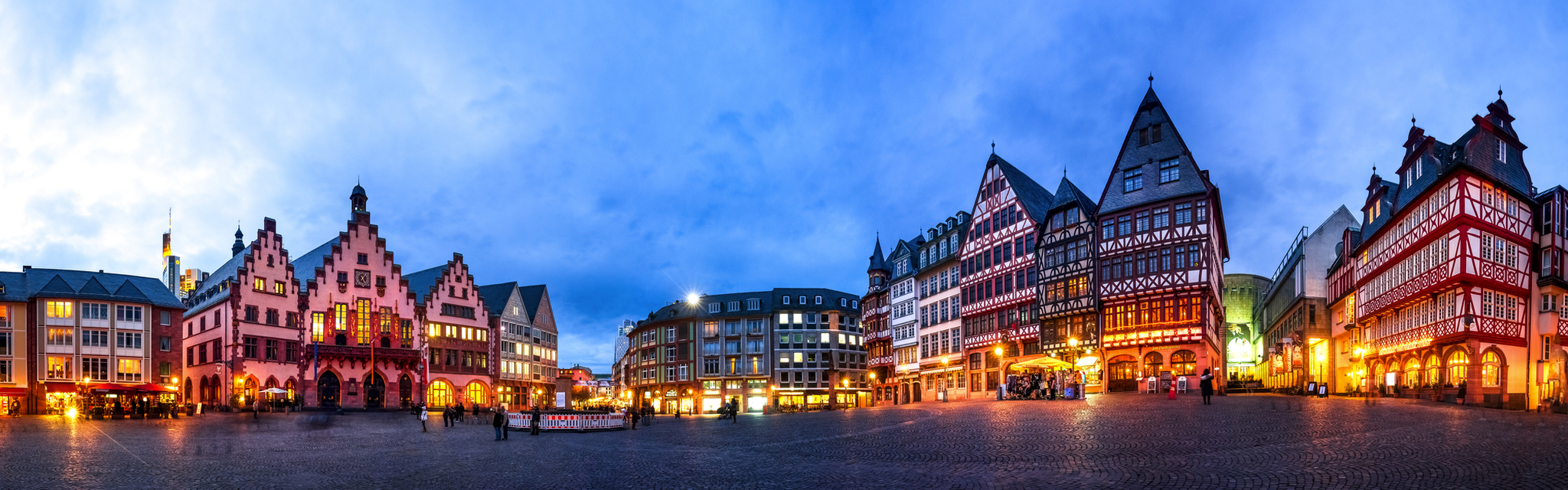 Panoramaansicht des Römers in Frankfurt am Main, Deutschland, mit historischen Fachwerkhäusern bei Abenddämmerung beleuchtet.