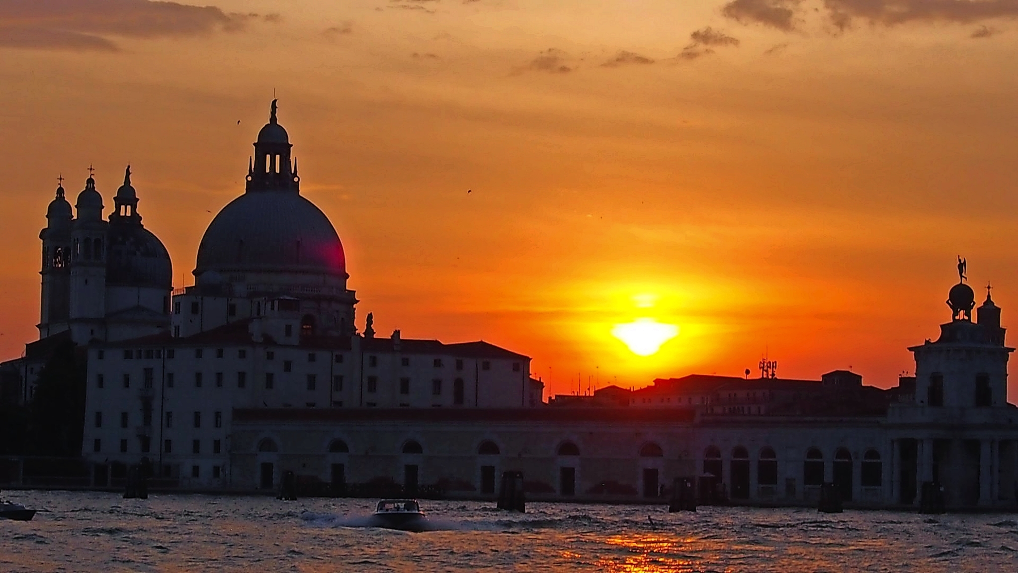 Venedig im Nordosten Italiens Sonnenuntergang über einer historischen Stadtlandschaft mit Kuppelgebäuden.