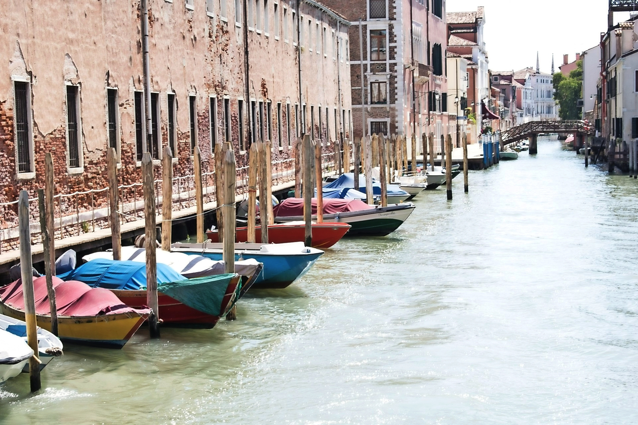 Venedig im Nordosten Italiens Boote am Kanal mit alten Gebäuden und Brücke im Hintergrund.