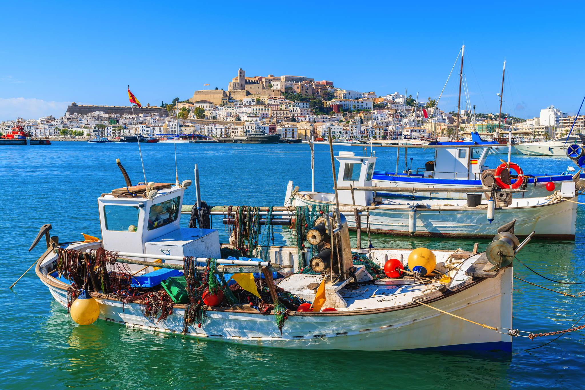 Fischerboot im Hafen mit Stadt und blauer Himmel im Hintergrund