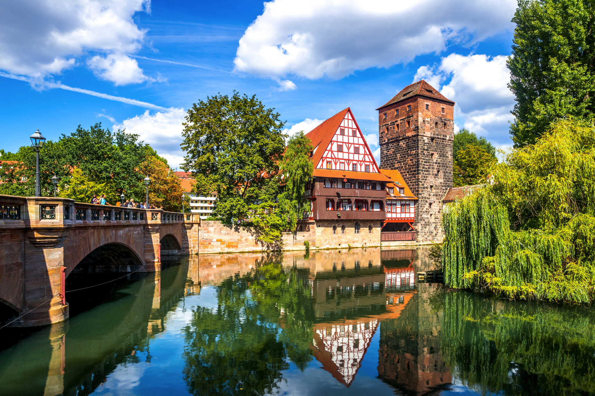 Fachwerkhaus und Turm am Fluss in Nürnberg unter blauem Himmel