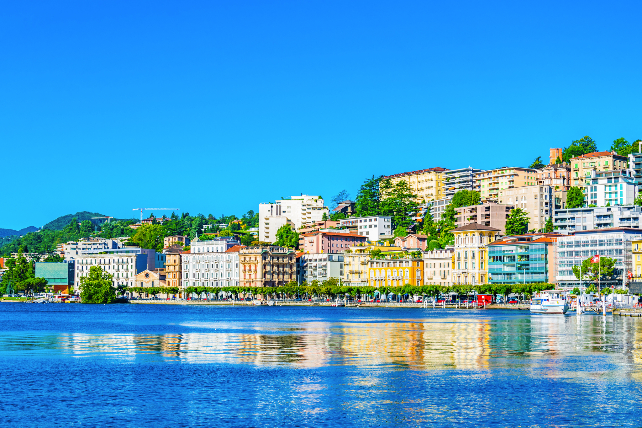 Panoramablick auf die Stadt Lugano am Ufer des Luganersees im Kanton Tessin, umgeben von den Alpen.