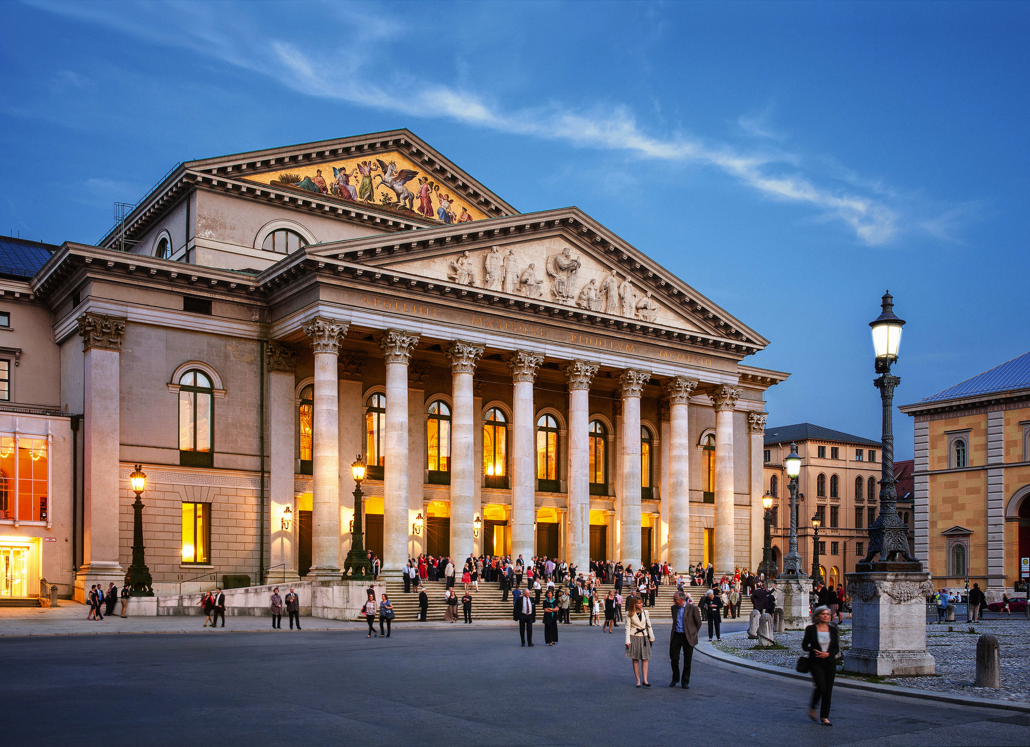 Bayerische Staatsoper bei Abenddämmerung mit erleuchteten Fenstern.