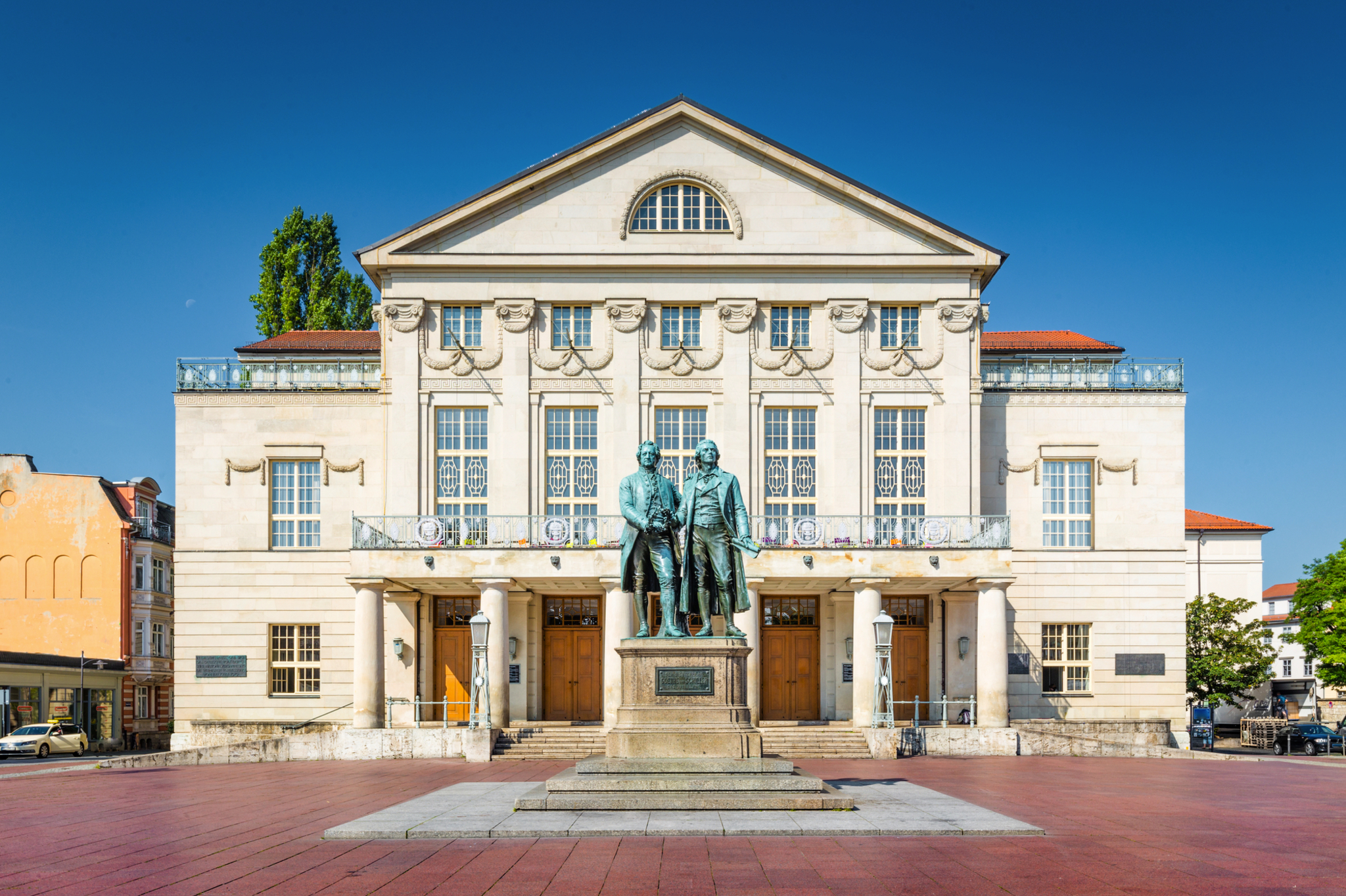 Das Bild zeigt das Goethe-Schiller-Denkmal vor dem Deutschen Nationaltheater in Weimar, Deutschland.