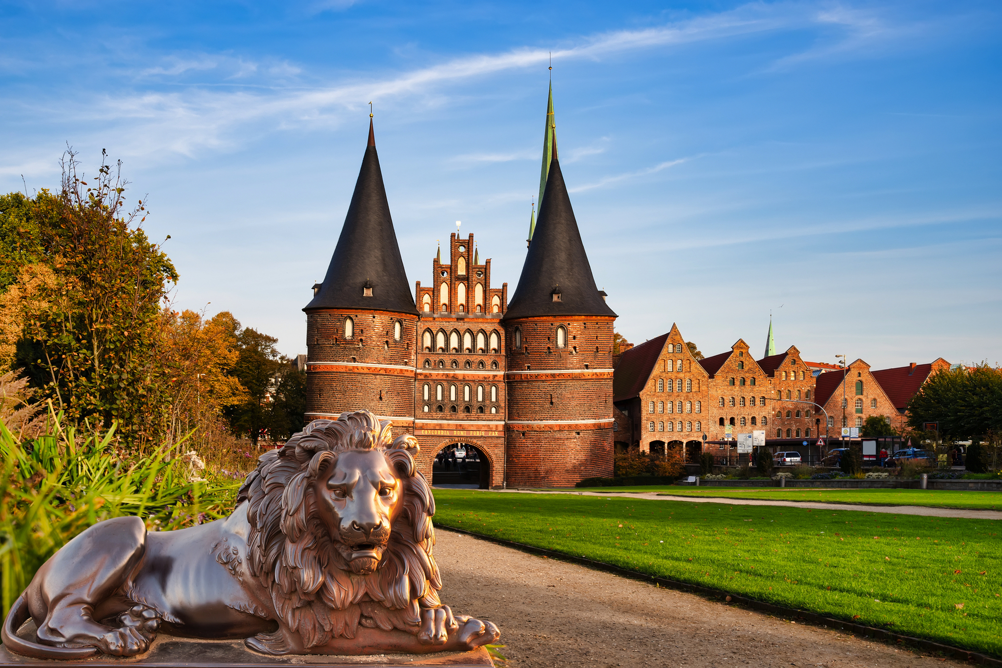 Lübecker Holstentor mit Löwenstatue im Vordergrund, historisches Stadttor in Lübeck, Deutschland.