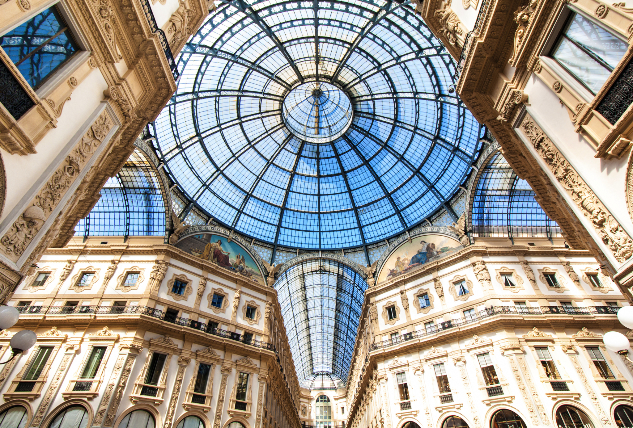 Blick durch ein gläsernes Kuppeldach auf historische Architektur.