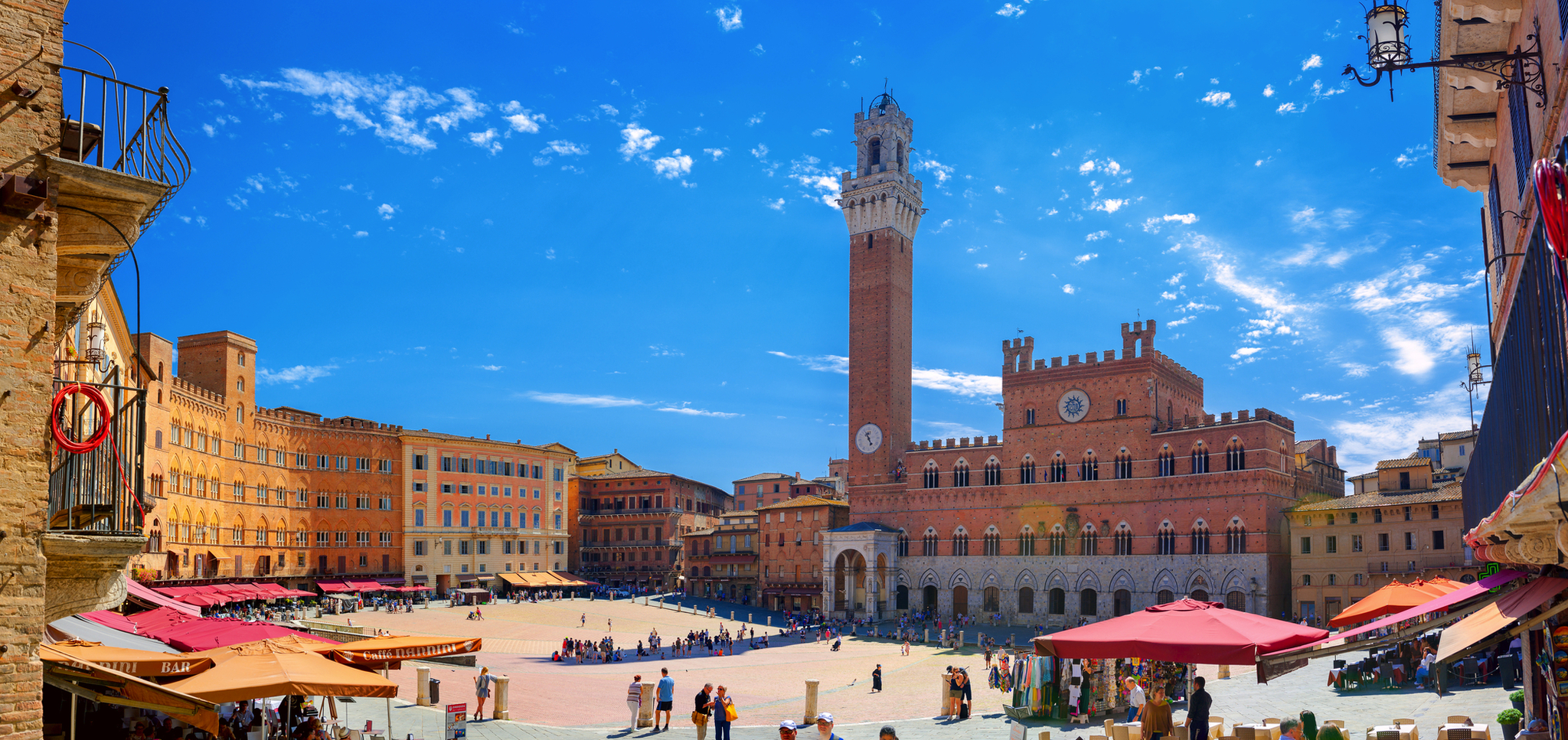 Marktplatz in Siena mit Blick auf die Piazza del Campo und den Palazzo Pubblico bei klarem Himmel.