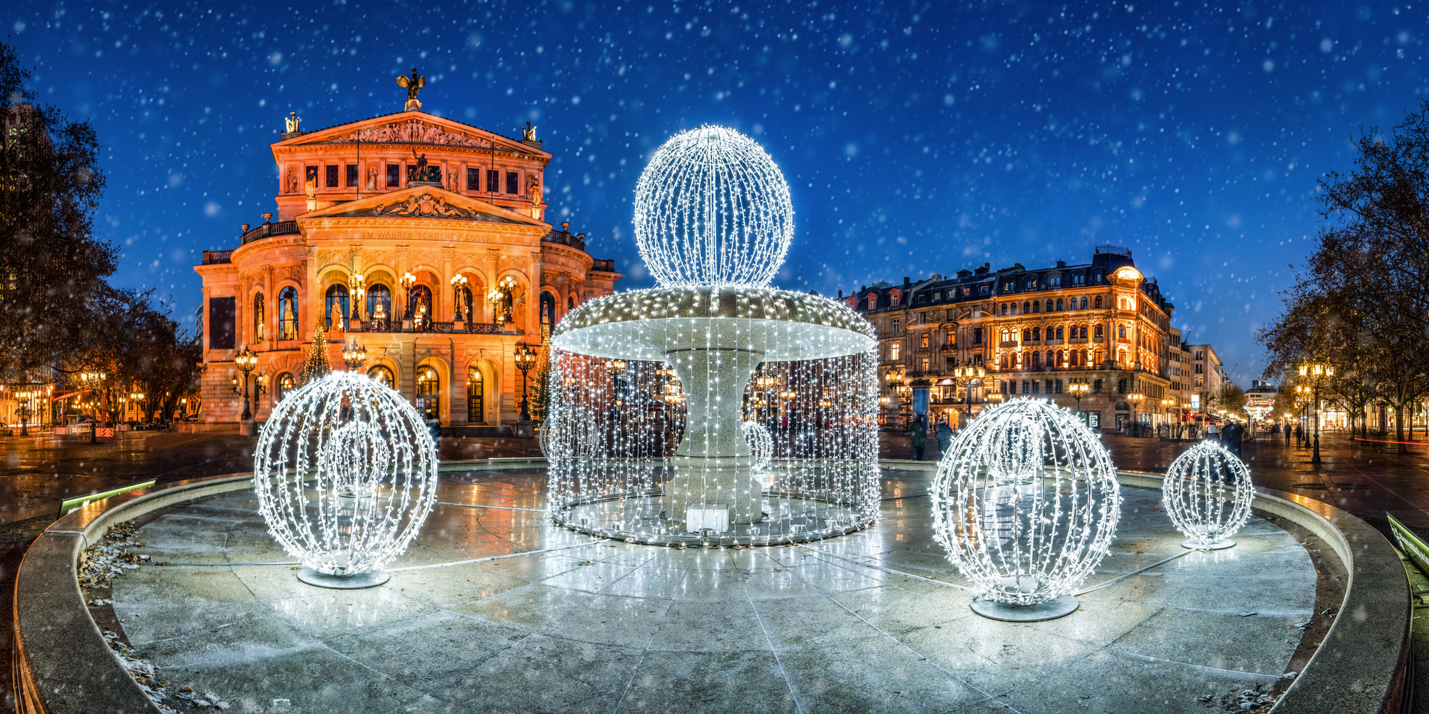 Alte Oper in Frankfurt am Main, Hessen, Deutschland, beleuchtet in der Nacht während der Adventszeit mit Schnee.