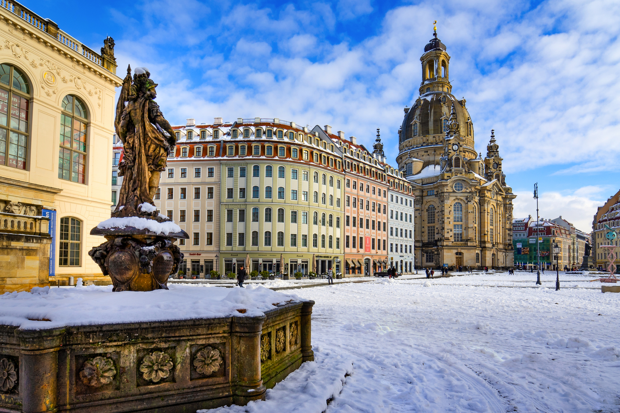 Dresden im Winter mit schneebedecktem Neumarkt und der barocken Frauenkirche im Hintergrund.