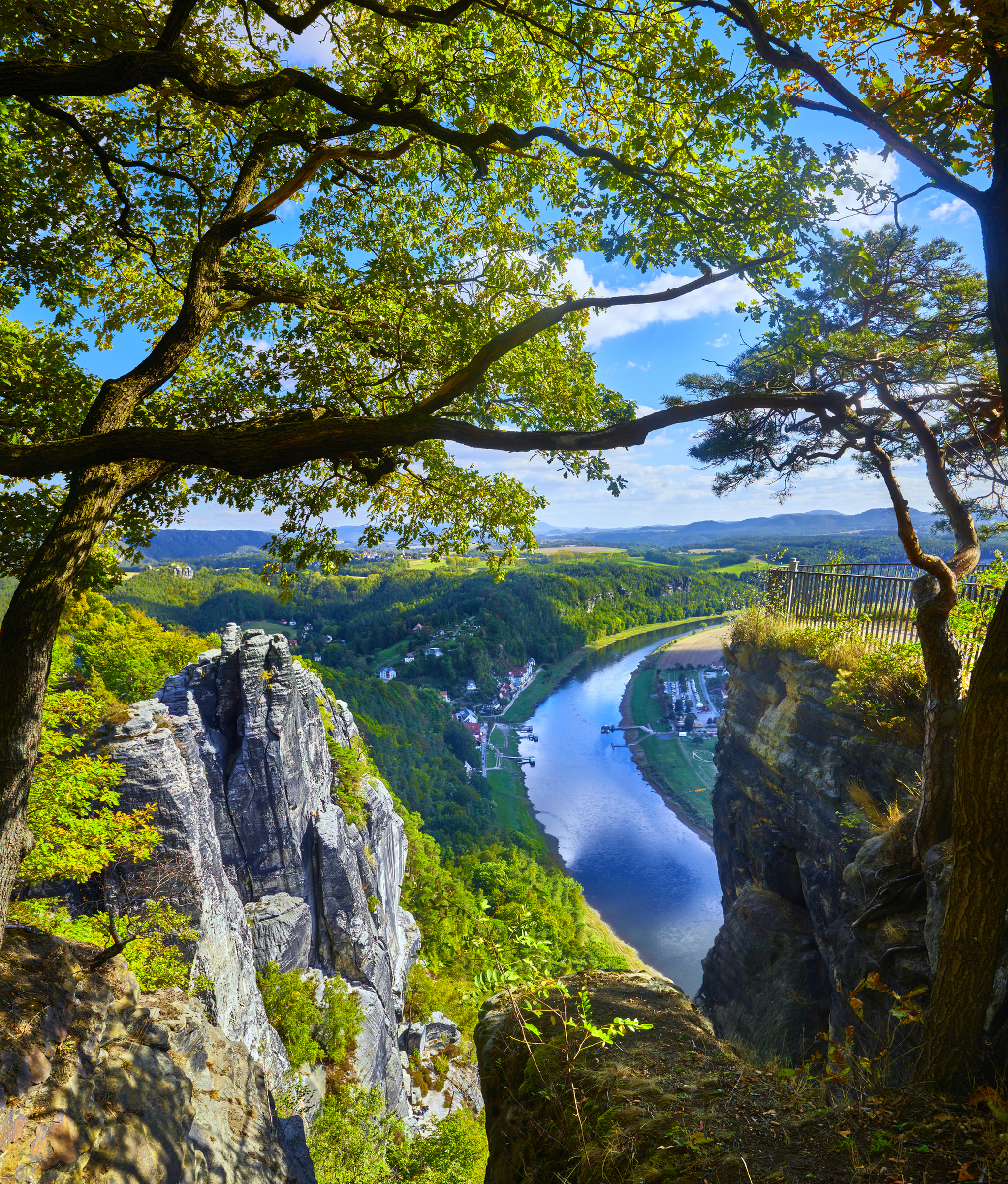 Blick auf Fluss zwischen Felsen und Bäumen in einer bergigen Landschaft.