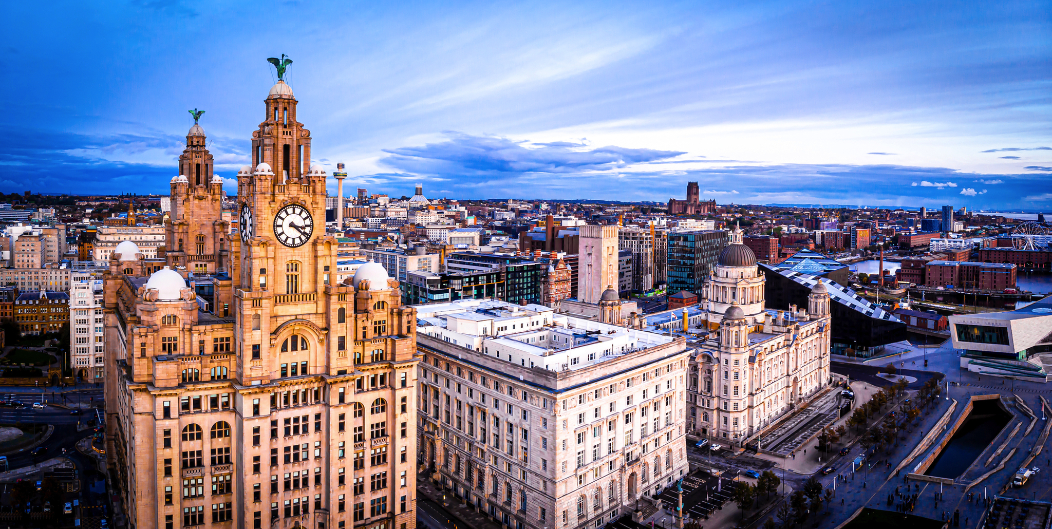 Royal Liver Building in Liverpool, England, mit Blick auf die Stadt im Hintergrund bei Tageslicht.