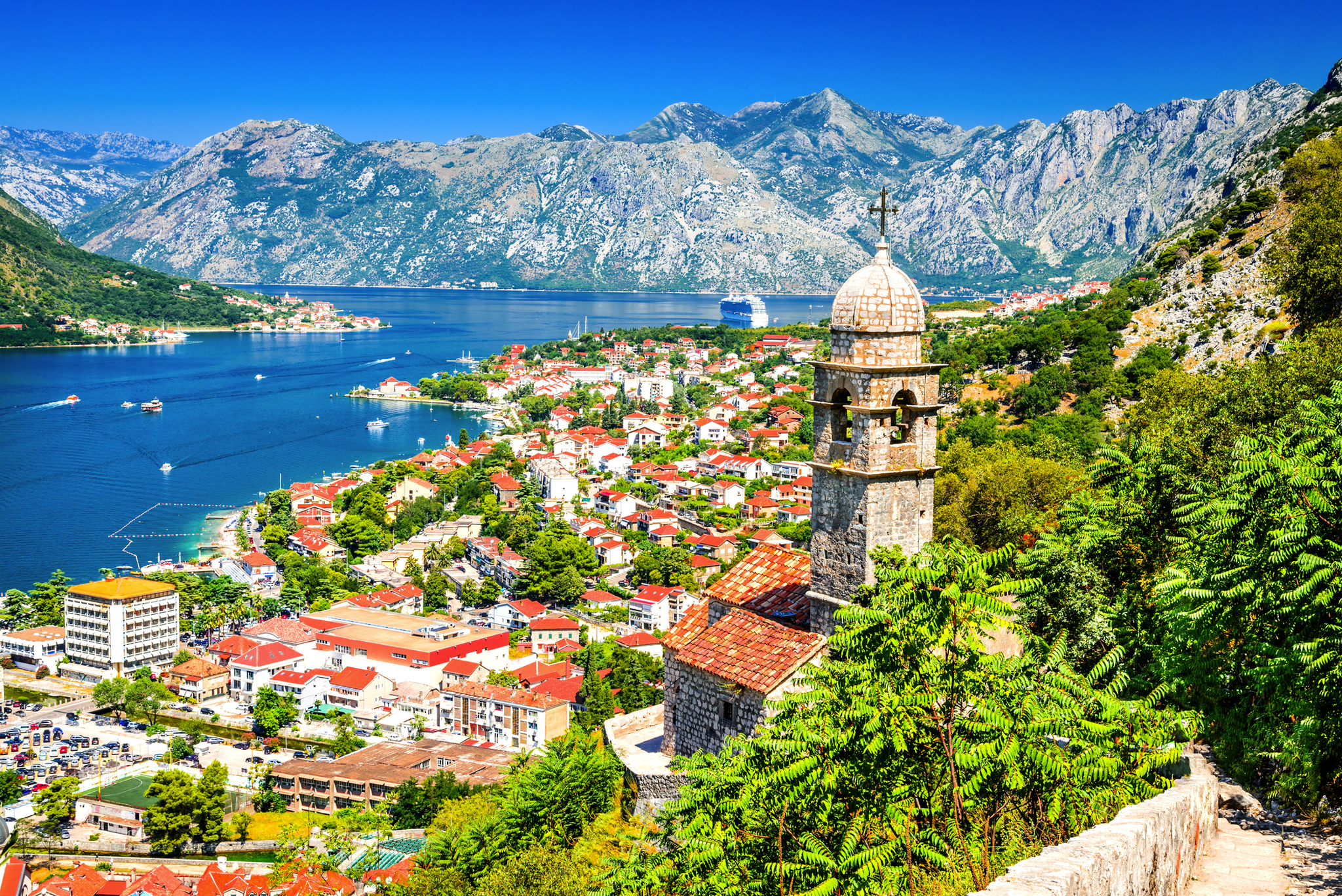 Mittelalterlicher Glockenturm mit Blick auf Küstenstadt Kotor, umgeben von Bergen und Meer.