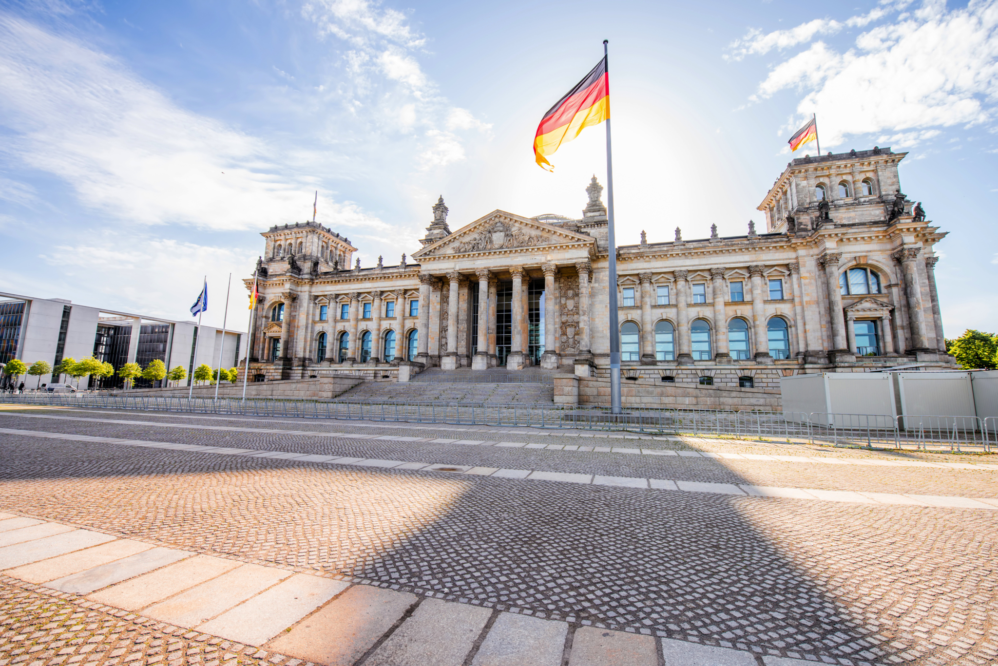 Berliner Reichstag Das Reichstagsgebäude in Berlin mit wehender deutscher Flagge.