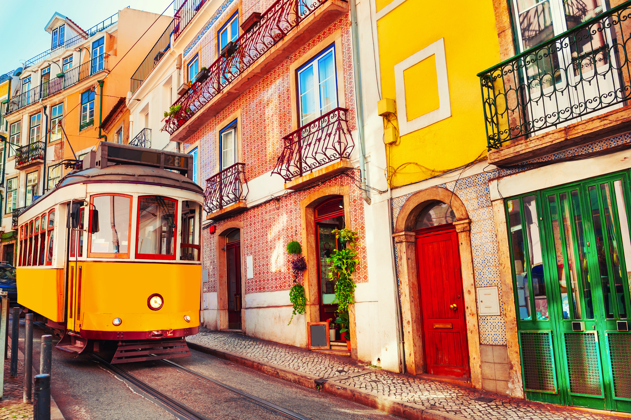 Straßenbahn Ascensor da Bica in der Altstadt von Lissabon, Portugal, umgeben von bunten Gebäuden.
