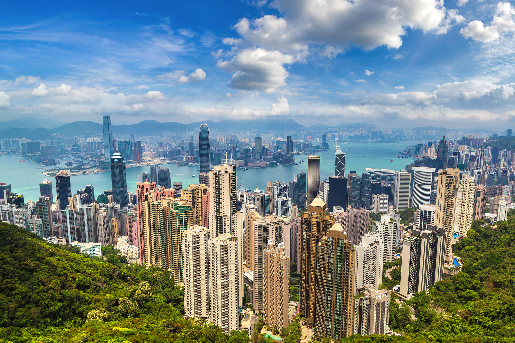 Stadtpanorama von Hongkong mit Wolkenkratzern und Hafen im Hintergrund.