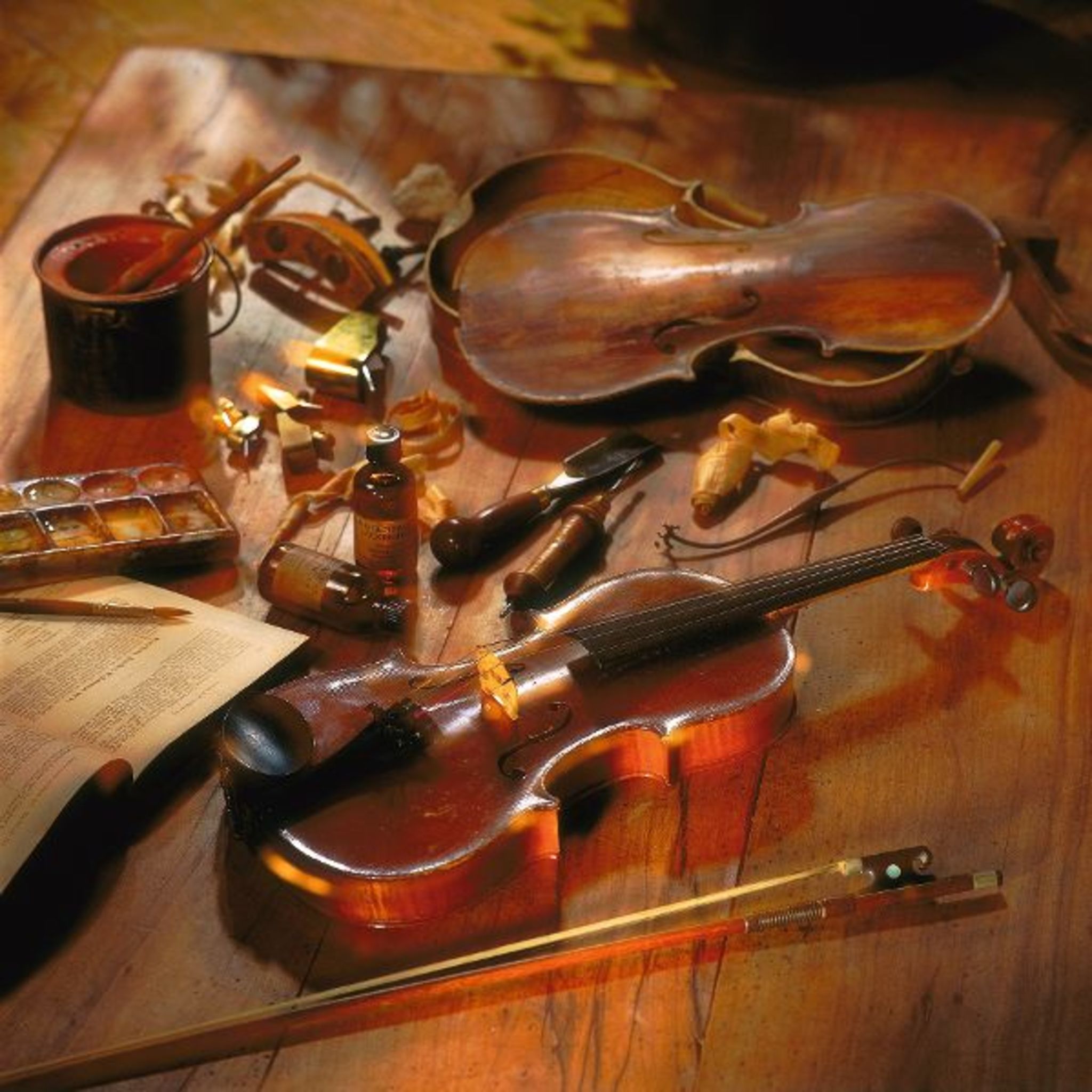 Werkbank eines Geigenbauers mit Geige, Werkzeugen und Materialien.