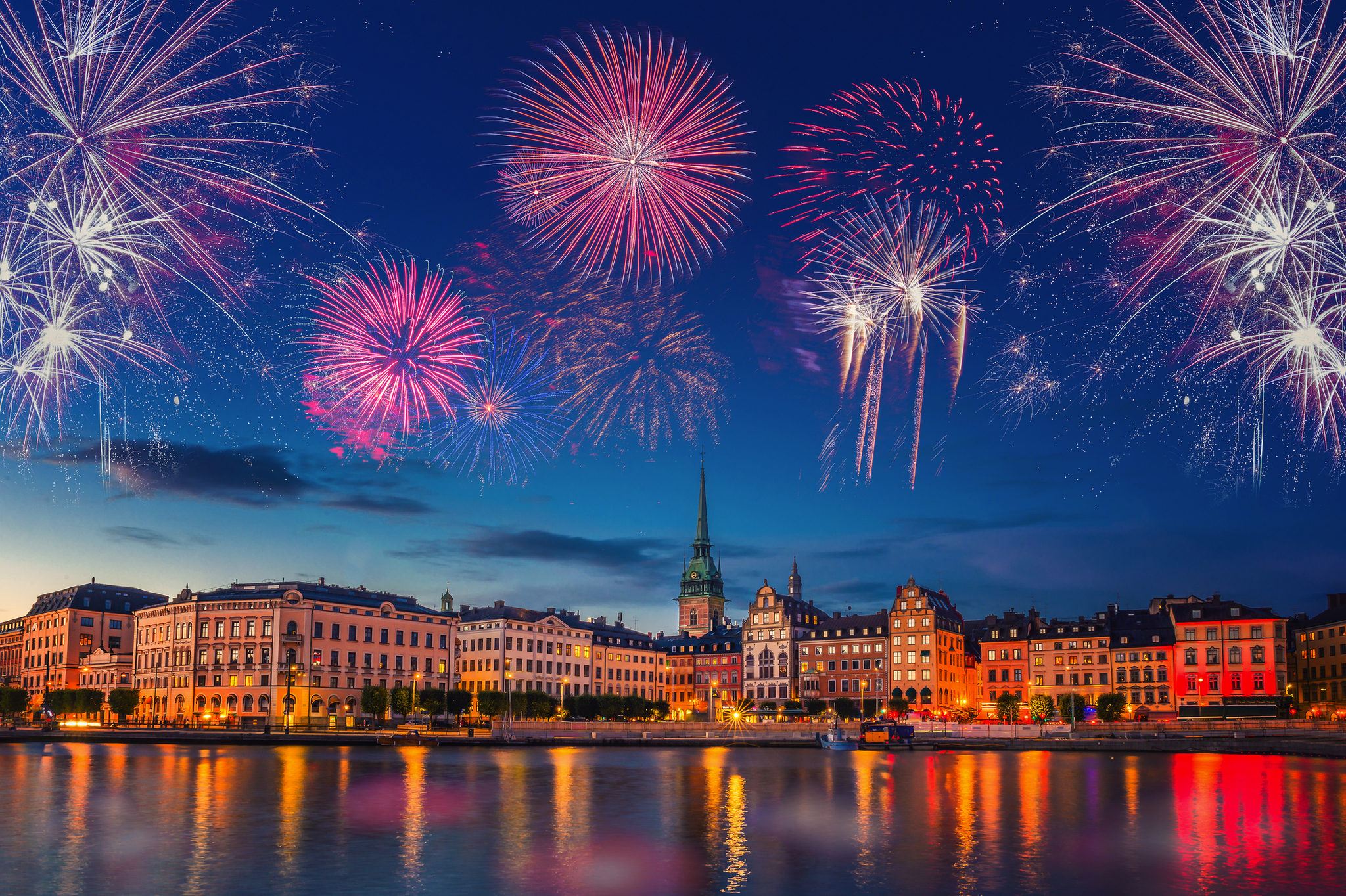 Feuerwerk über einer Stadt mit beleuchteten Gebäuden bei Nacht.