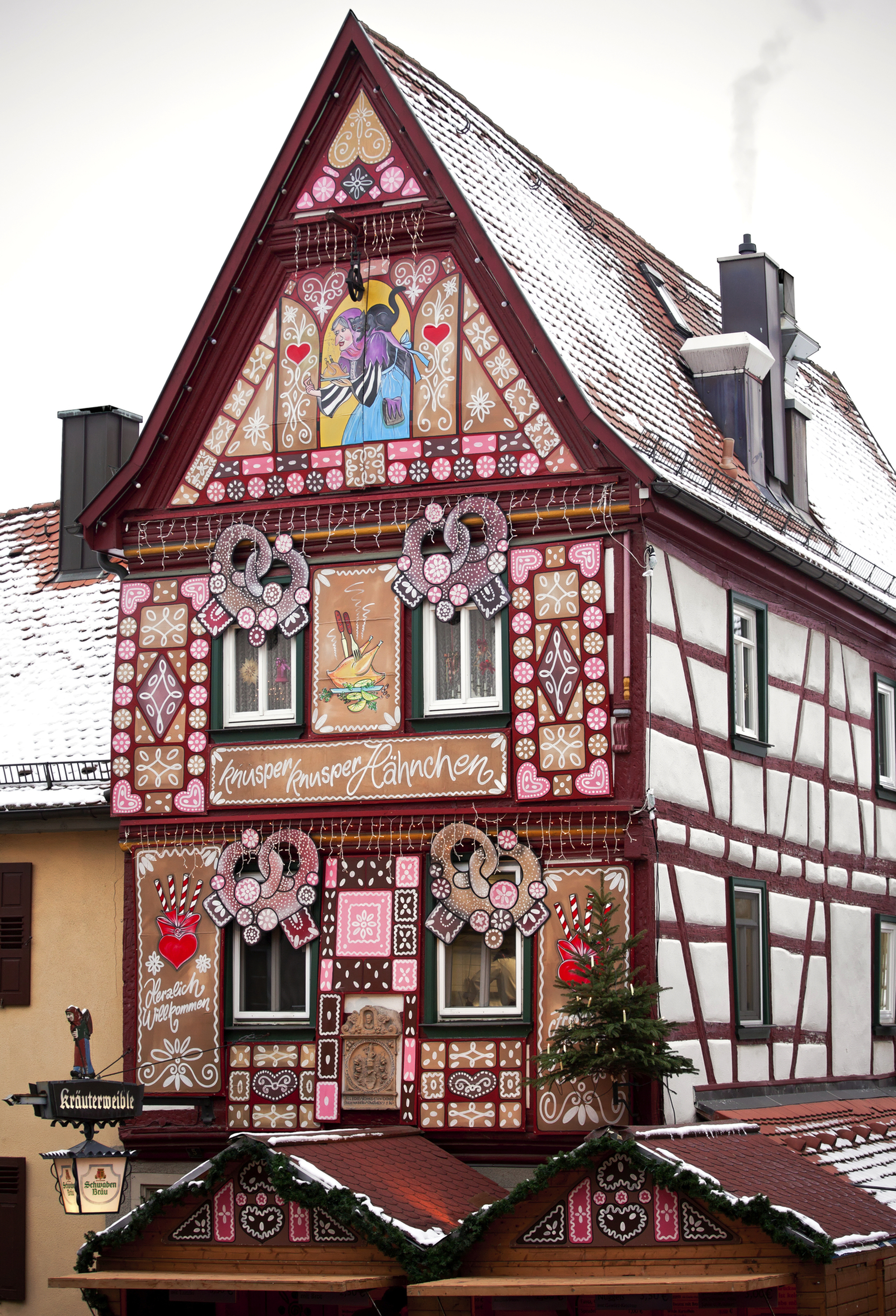 Fachwerkhaus im Lebkuchen-Stil dekoriert mit Winterlandschaft im Hintergrund.