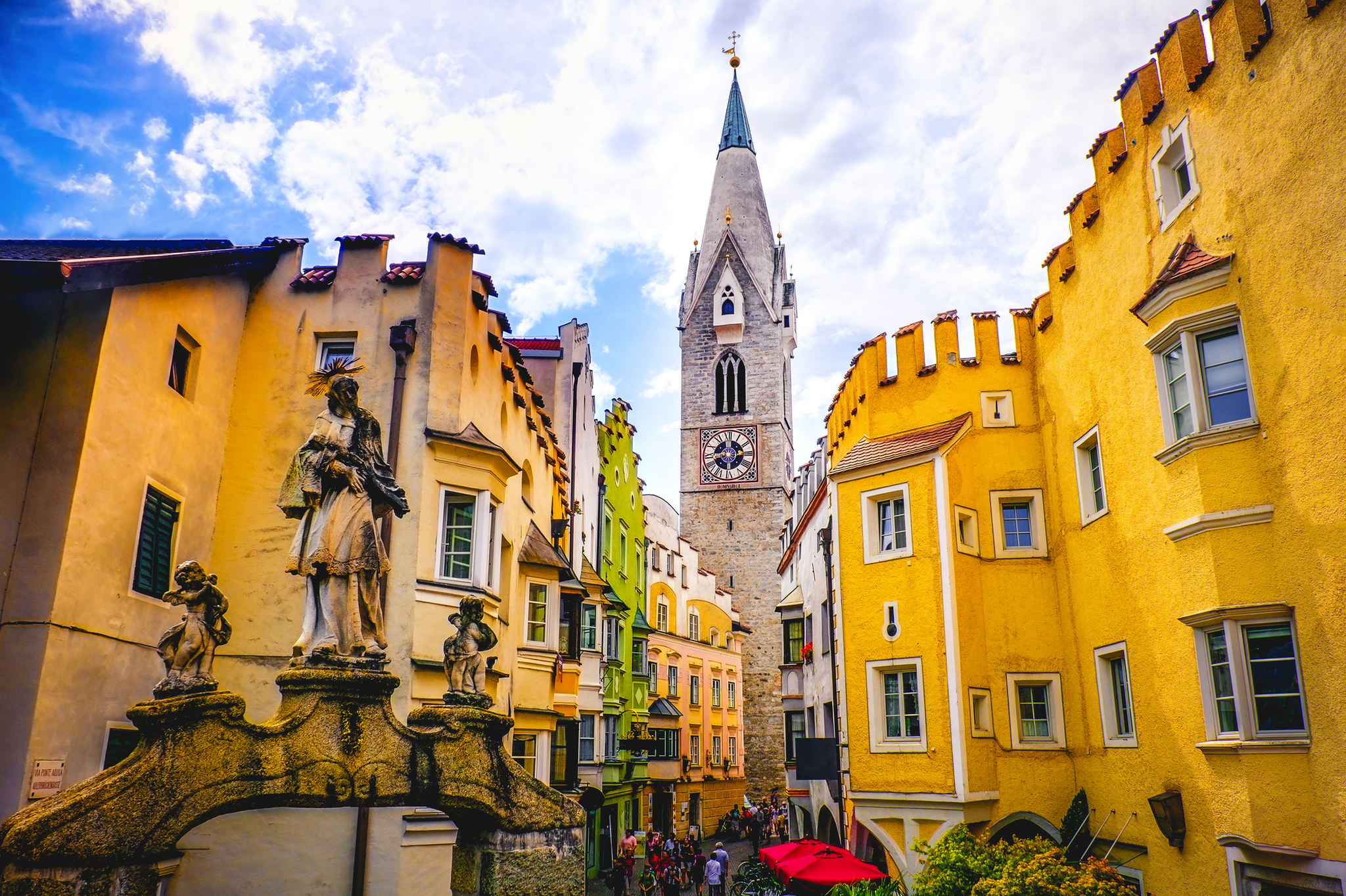 Häuserfassaden und Kirchturm an einem sonnigen Platz in Italien.