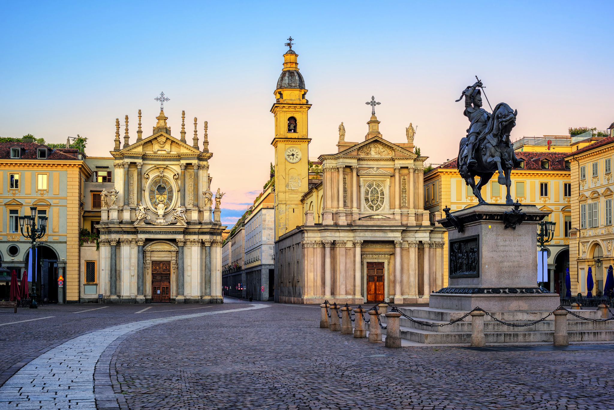 Historischer Platz mit Kirche und Reiterstatue bei Sonnenuntergang.