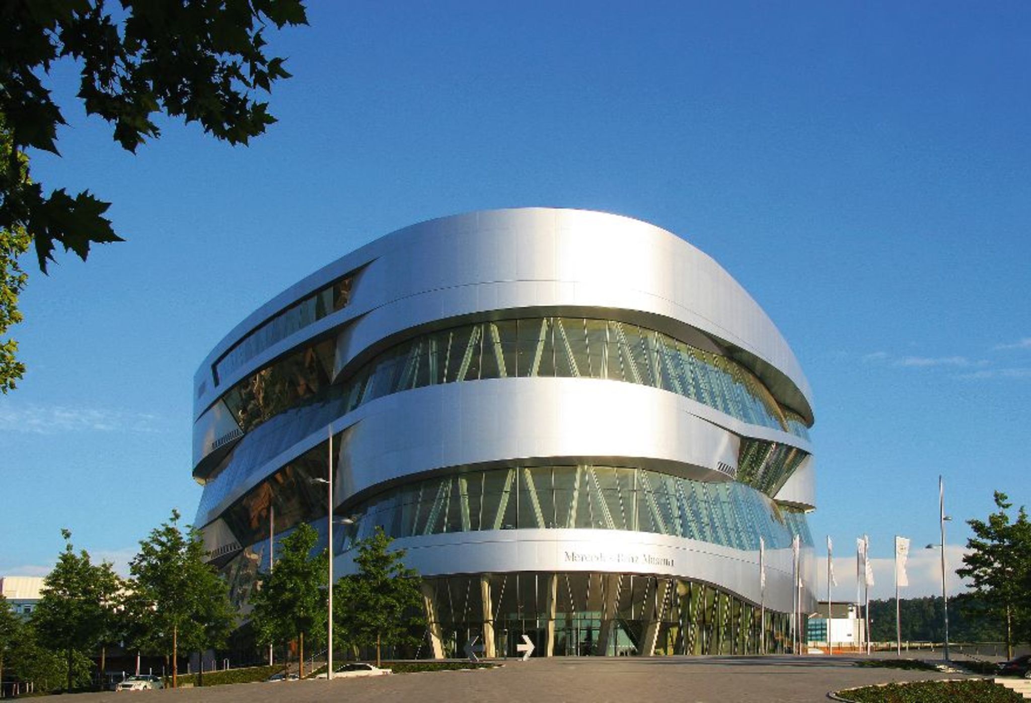Futuristisches Gebäude des Mercedes-Benz Museums bei blauem Himmel.