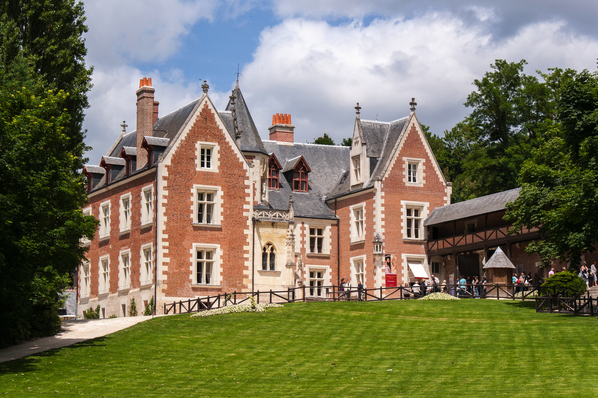 Herrenhaus mit Backsteinfassade und Garten bei sonnigem Wetter.