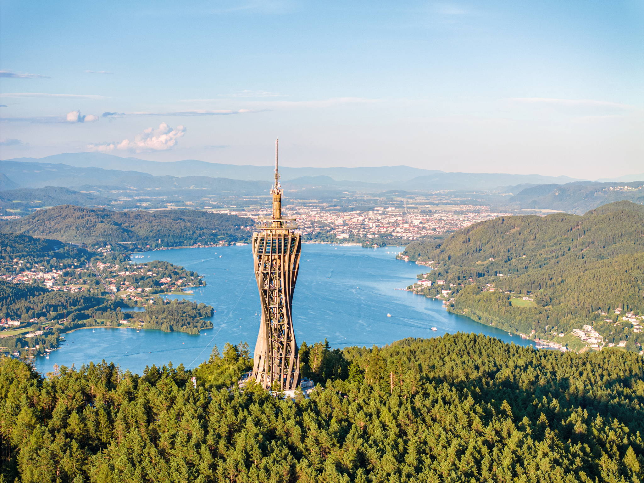 Aussicht vom Pyramidenkogel mit Blick auf den Wörthersee in Kärnten, umgeben von Wald und Bergen.
