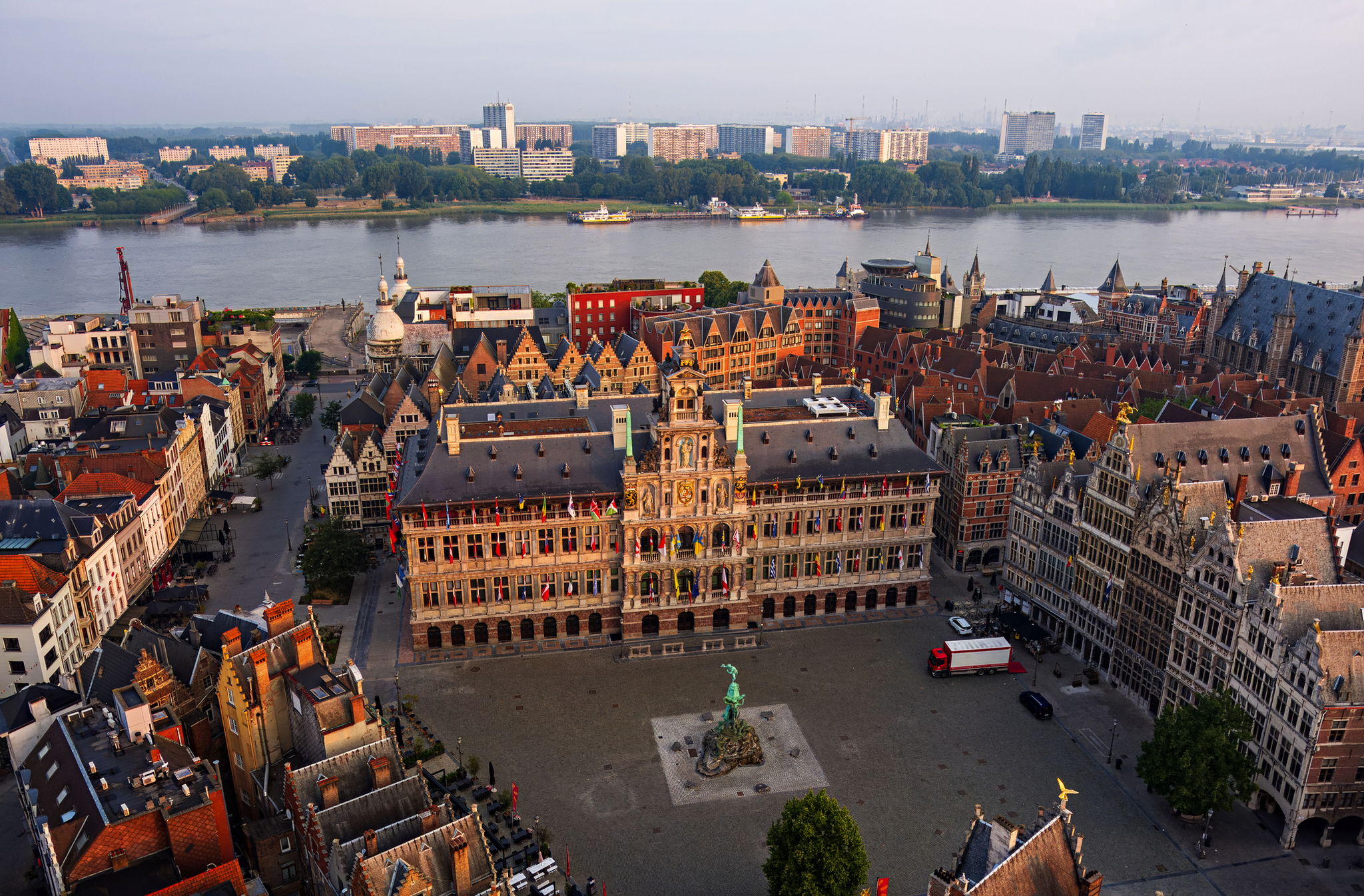 Stadtplatz mit historischen Gebäuden und Fluss im Hintergrund.