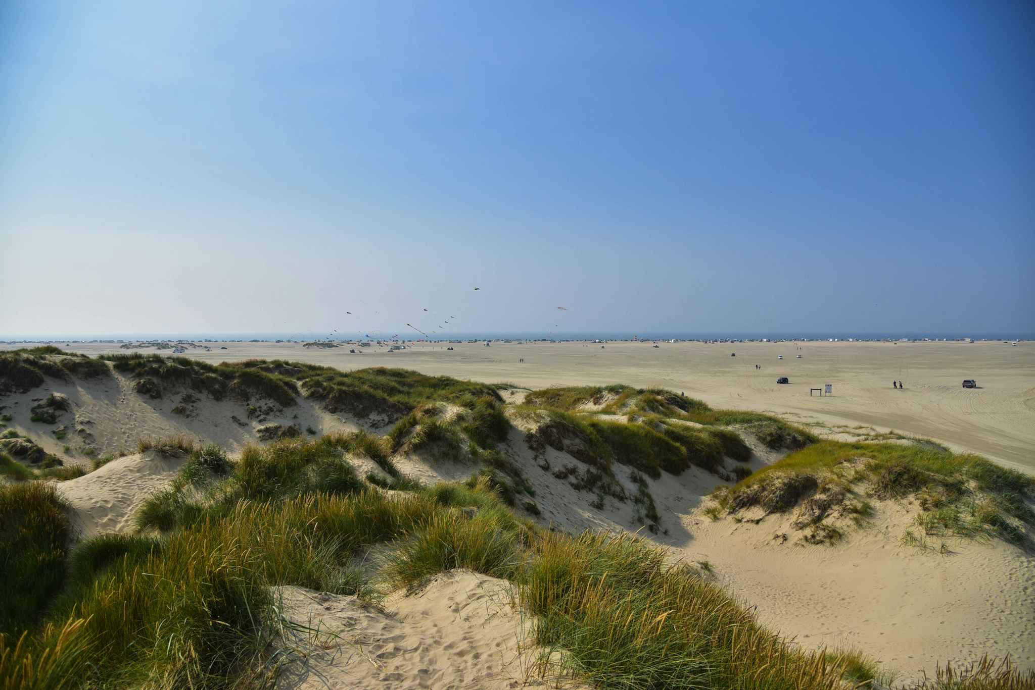 Dünenlandschaft am Strand unter klarem Himmel.