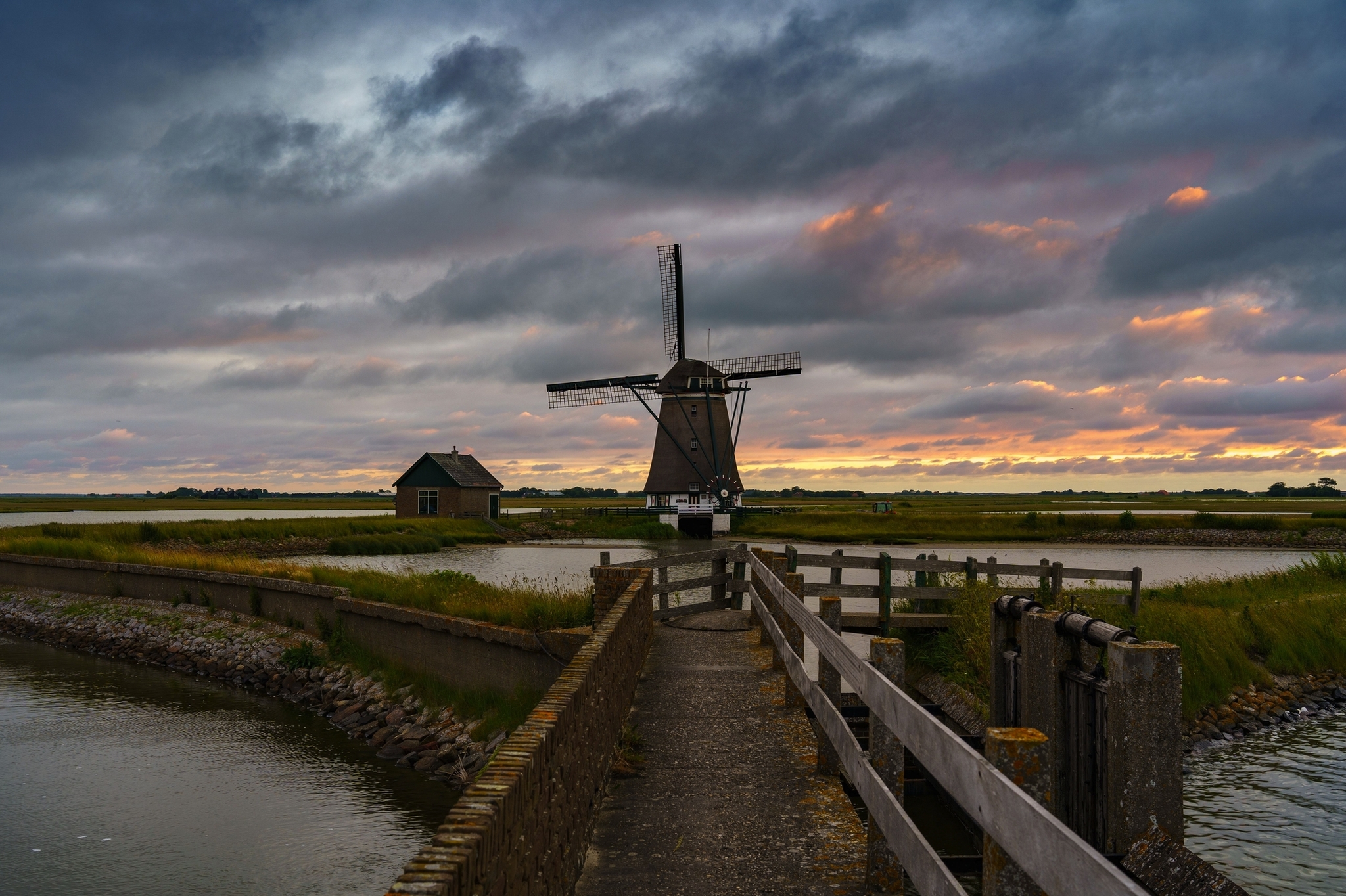 Windmühle an einem kleinen See bei Sonnenuntergang in den Kagerplassen, Südholland, Niederlande.