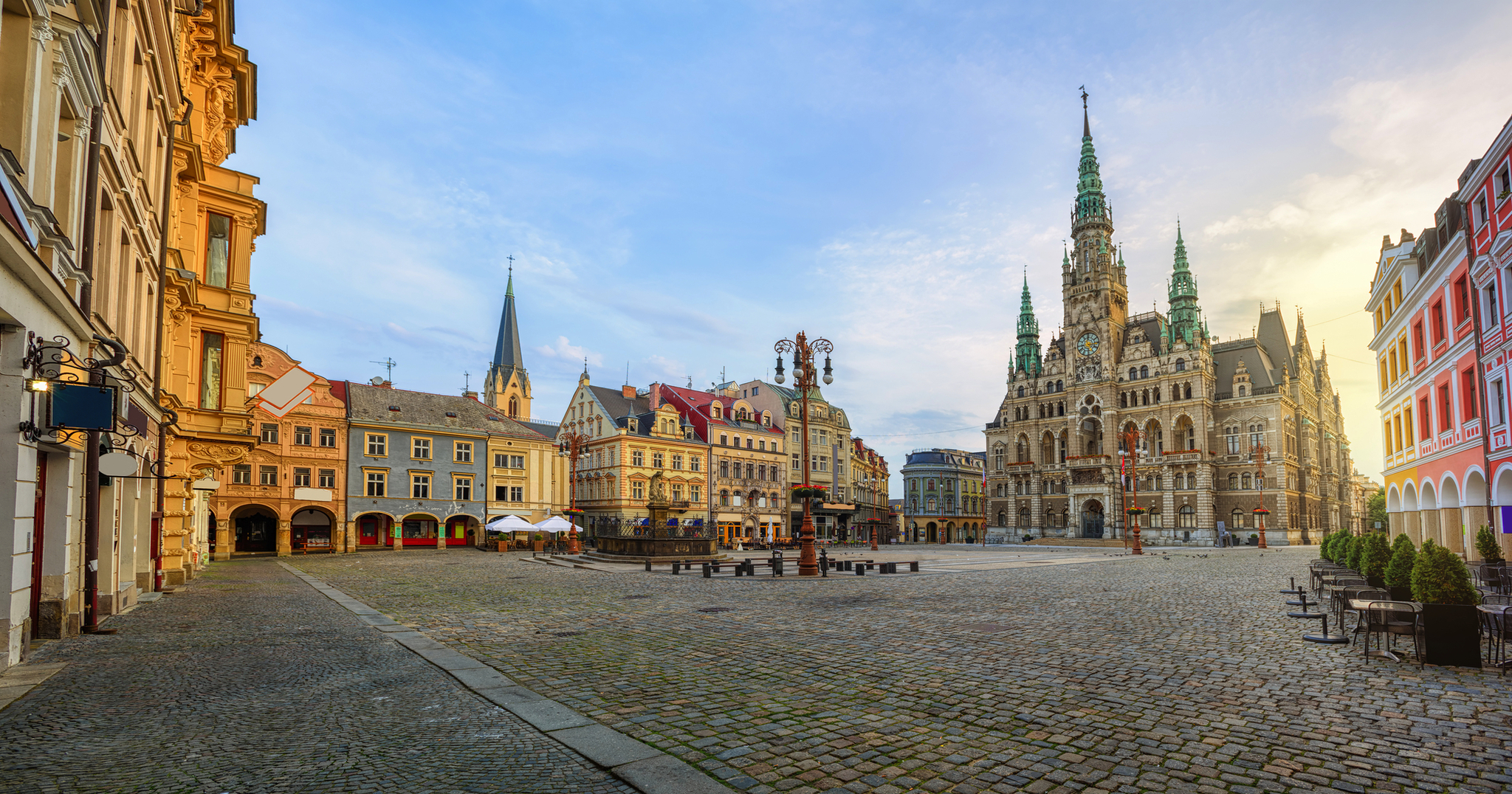 Historischer Platz mit Rathaus und alten Gebäuden bei Sonnenuntergang.