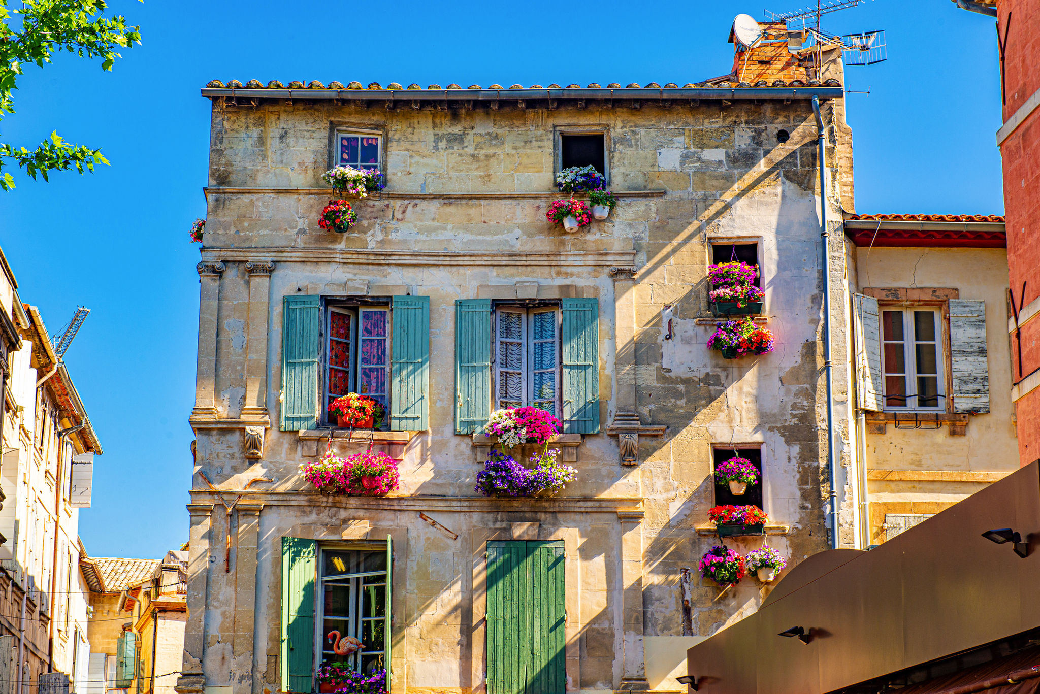 Historisches Gebäude mit bunten Blumen an den Fenstern.