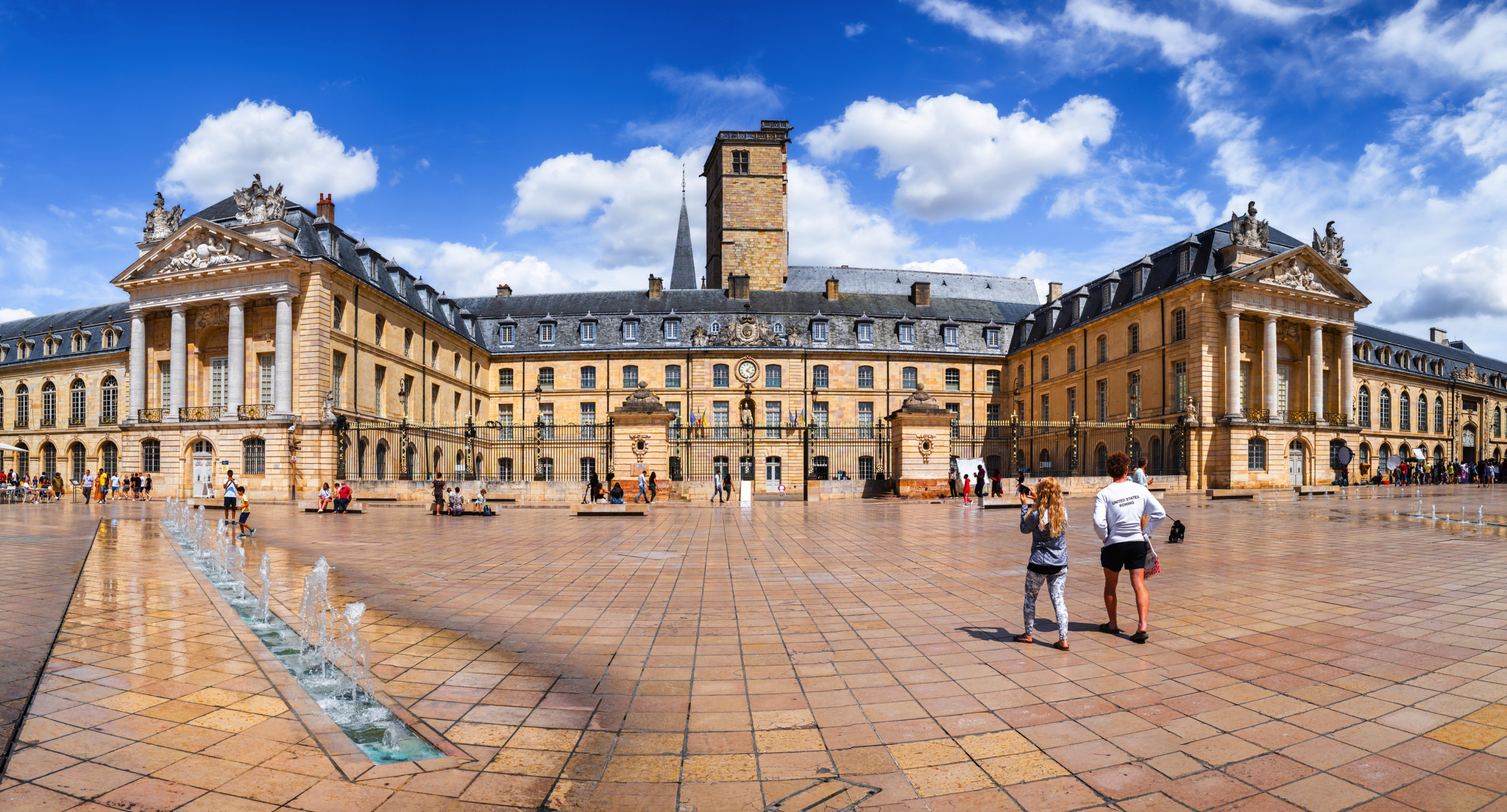 Historisches Gebäude mit gepflastertem Platz und blauem Himmel.