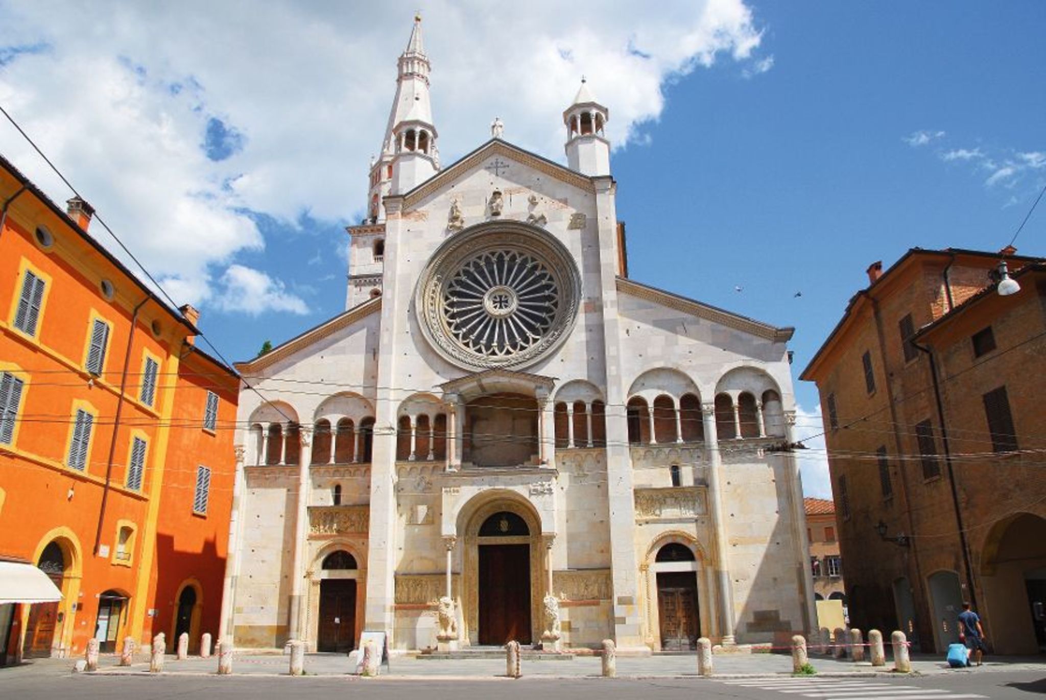 Kathedrale von Modena mit Rosettenfenster und Türmen bei blauem Himmel.