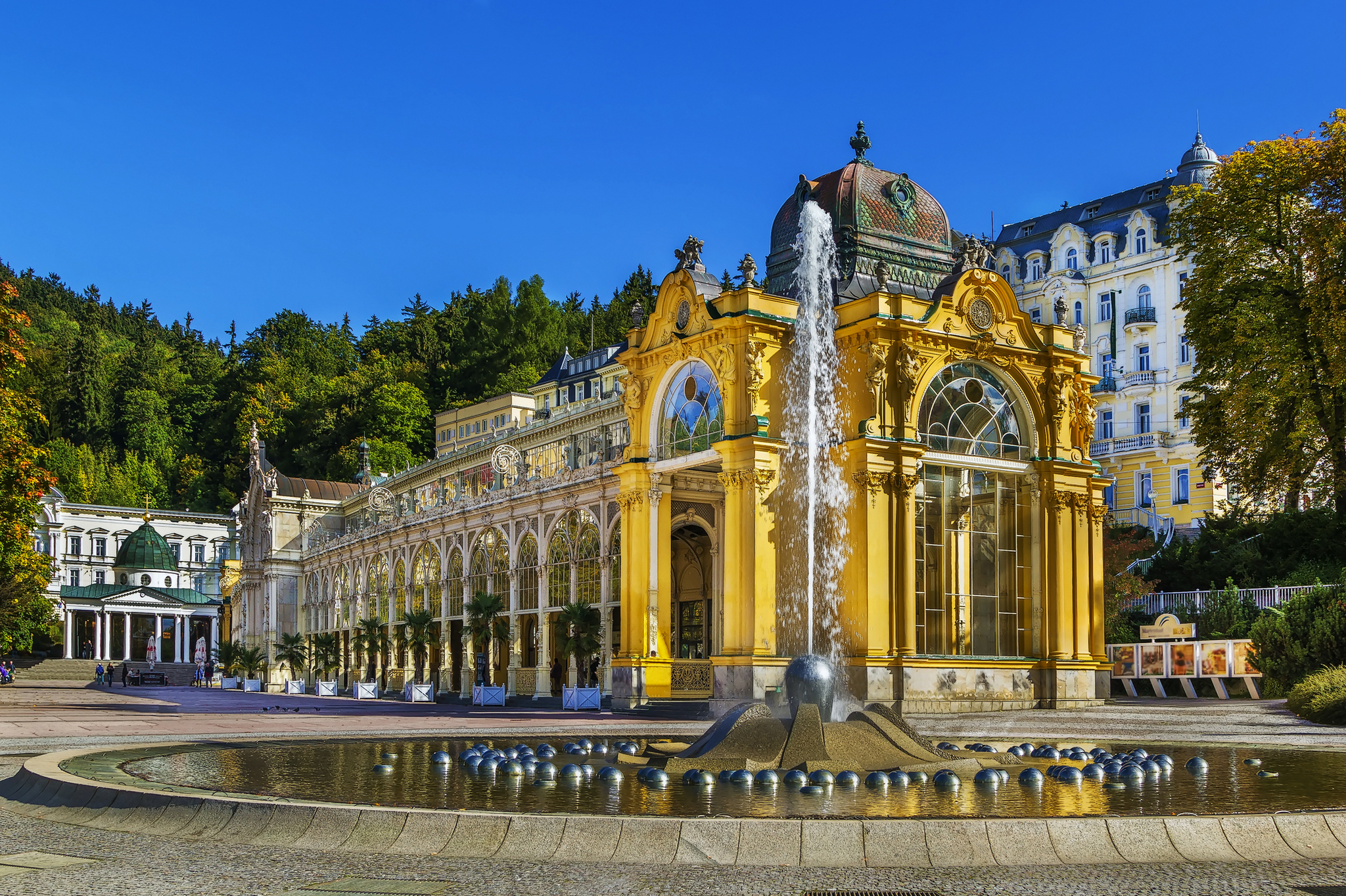Kurhausgebäude mit Springbrunnen im Vordergrund und blauem Himmel im Hintergrund.